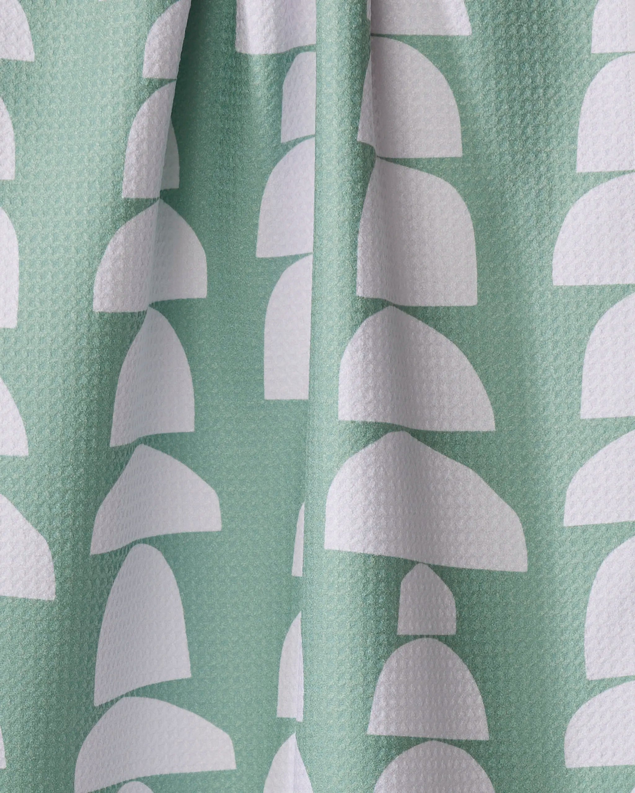 Breakfast at Granny's by Claire Iglesias is a textured green tea towel made from recycled materials, featuring white semi-circular arches in vertical rows. Its softly gathered fabric adds stylish folds for an eco-friendly look.