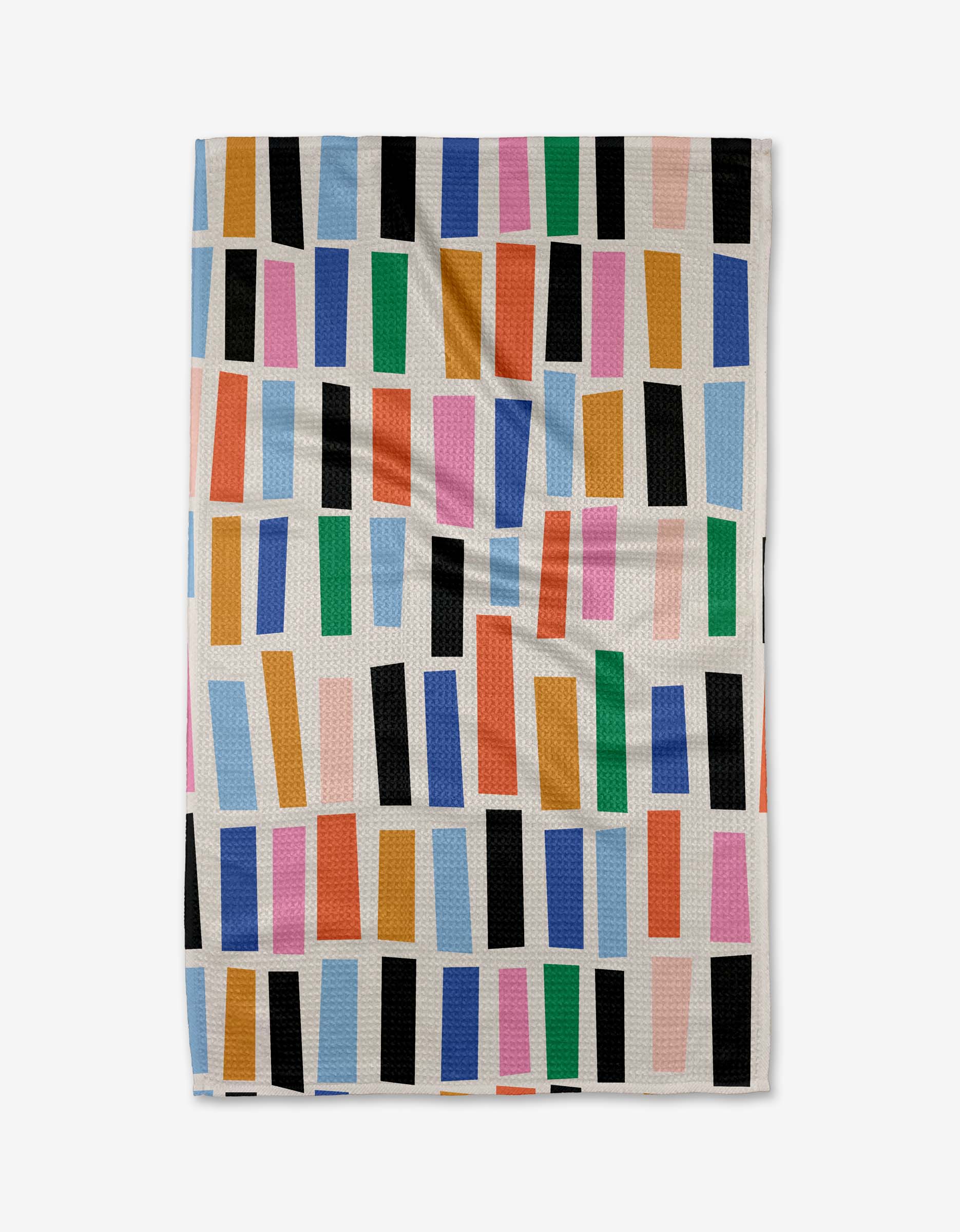 The Bricks kitchen towel by Jennifer Bouron is white, made from recycled fabric, and features colorful staggered rectangles in blue, green, orange, pink, and black. The slightly wrinkled towel is shown against a plain background.