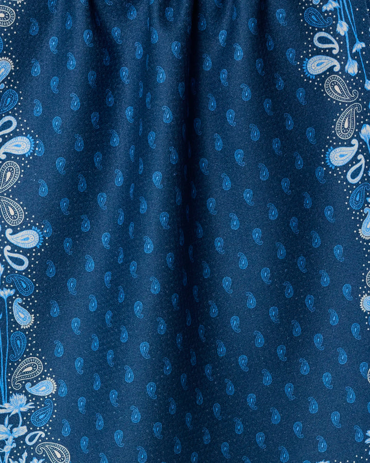 Close-up of Geometry's Bronco Indigo dish towel, featuring a dark blue absorbent fabric with light blue and white paisley patterns—small motifs at the center and bold decorative edges—perfect for adding stylish flair to your kitchen.