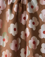 Geometry’s Brushed Bouquet Brown features brown eco-friendly fabric with white flowers, pink centers, and red dots. Soft folds and subtle shadows create a 3D effect—perfect for a charming kitchen towel.