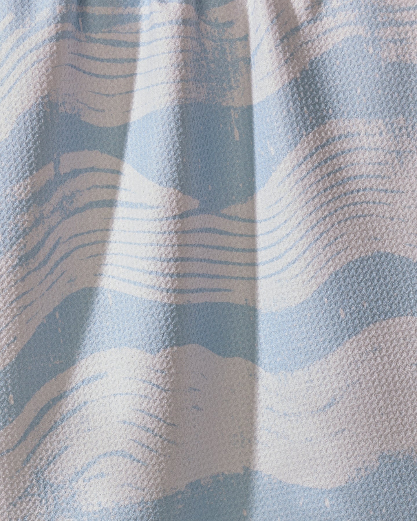 A close-up of Geometry’s Brushline Lightblue shows wavy, brushstroke-like stripes in light blue and white—ideal for an ultra-absorbent or recycled kitchen towel.