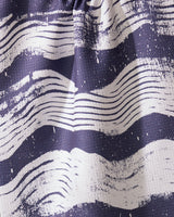 A close-up of Geometrys Brushline Navy tea towel, featuring quick-drying fabric and wavy, hand-drawn white stripes on a dark blue background for a dynamic, artistic texture.