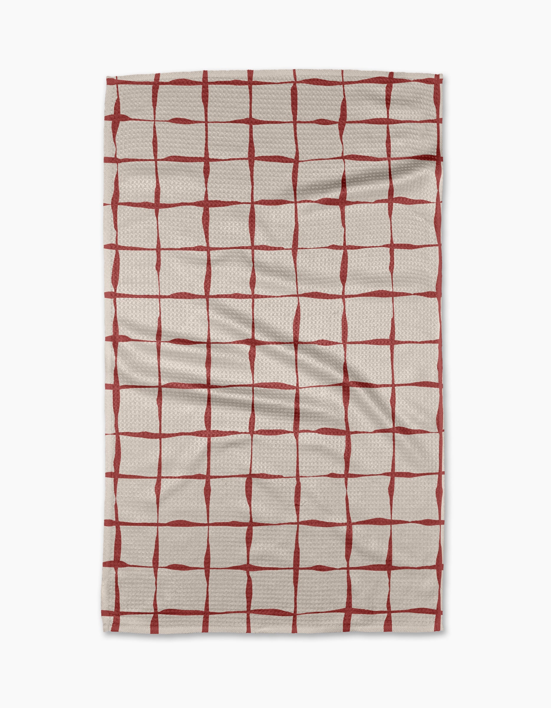 The Brushstroke Checks kitchen towel by Linda Fox is a beige, recycled fabric towel with irregular red grid lines and visible surface creases.