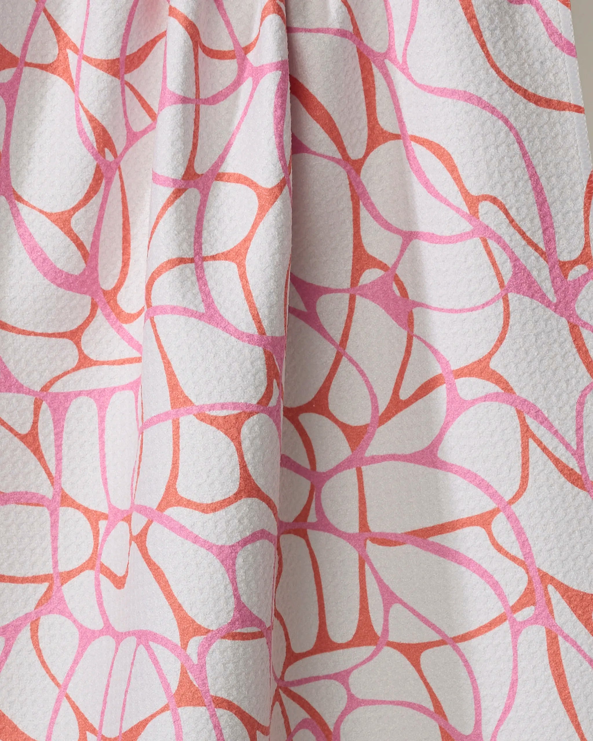 Close-up of the Rachel Parker "Bubble Abstract" tea towel, made from recycled materials with a white textured fabric and organic, web-like pink and coral abstract lines. Ultra-absorbent and eco-friendly design.