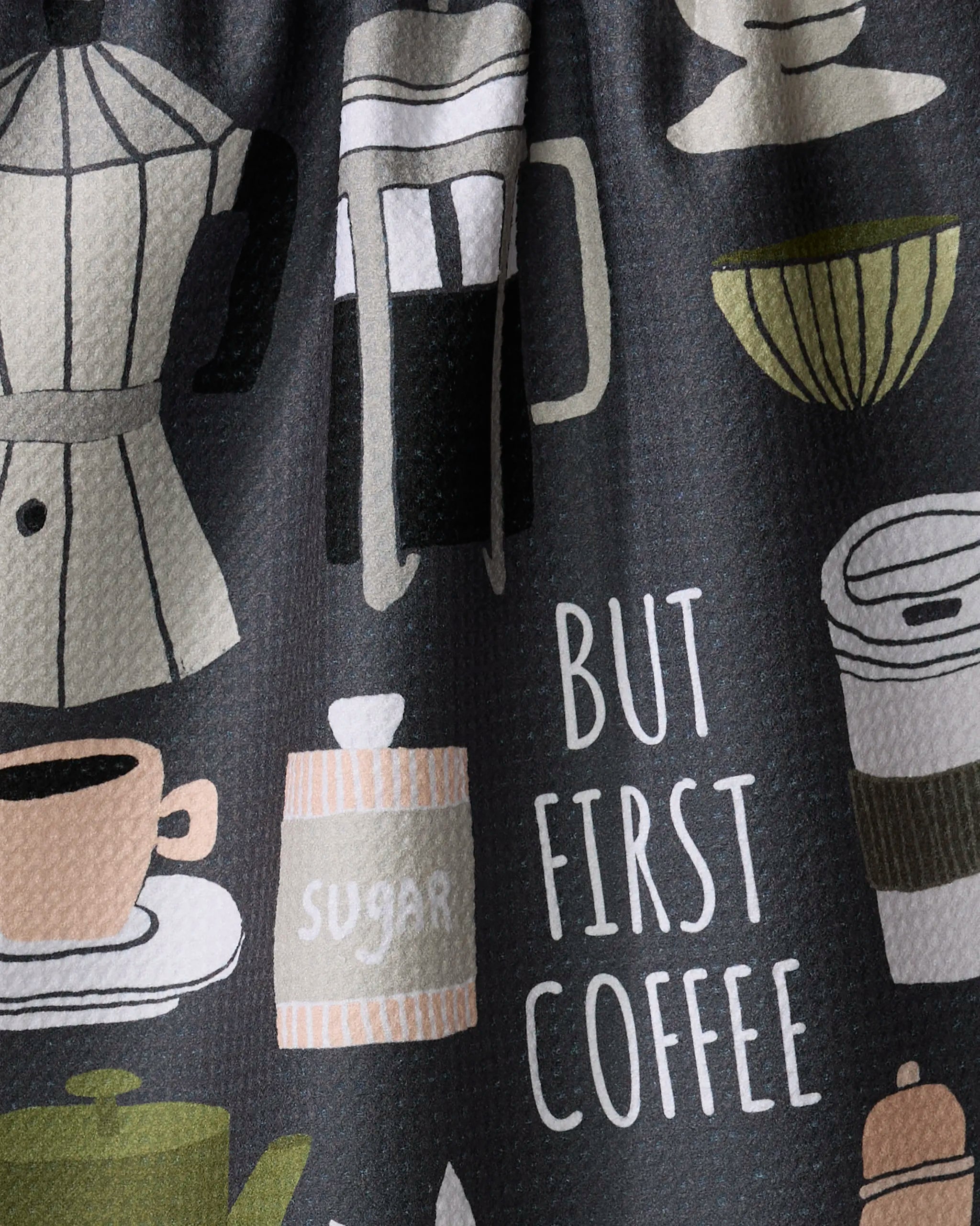 The But First, Coffee tea towel by Cottonflower Studio is made from recycled materials and features quick-drying fabric with illustrations of coffee makers, cups, a sugar jar, and more—all with "BUT FIRST COFFEE" in bold white letters.