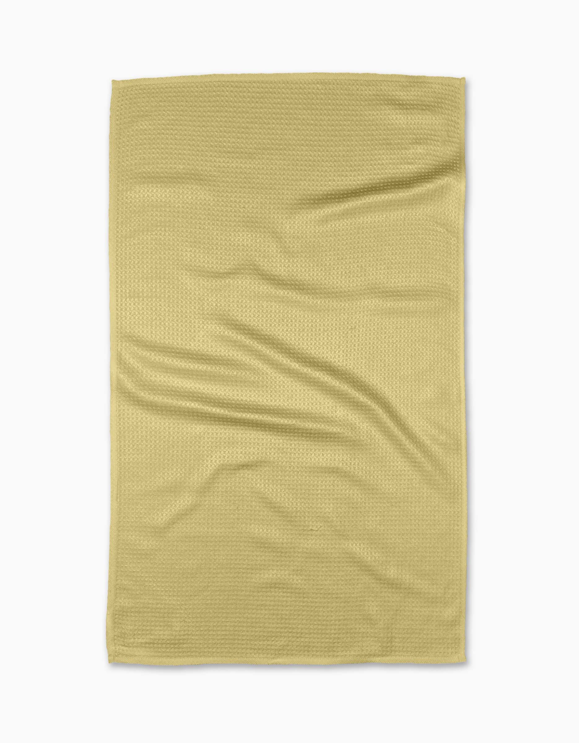 A Butter Yellow Kitchen Tea Towel by GEOMETRY, made from soft Geoweave™ fabric, is laid flat on a white surface, showing gentle creases and folds.