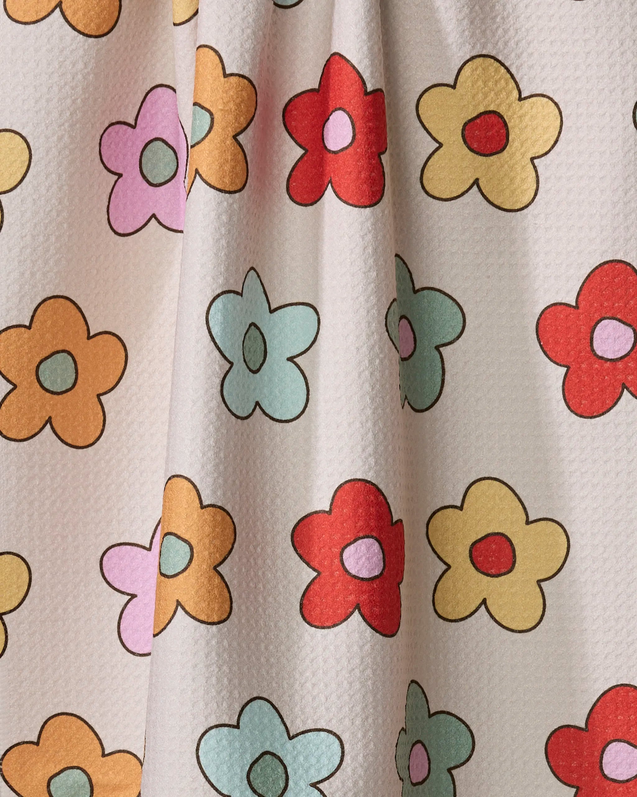 Purely Kaylie’s Buttercream Blossoms kitchen towel features a playful floral design—red, yellow, orange, pink, and light blue flowers outlined in black on a soft white textured fabric. Made from recycled materials for an eco-friendly touch.