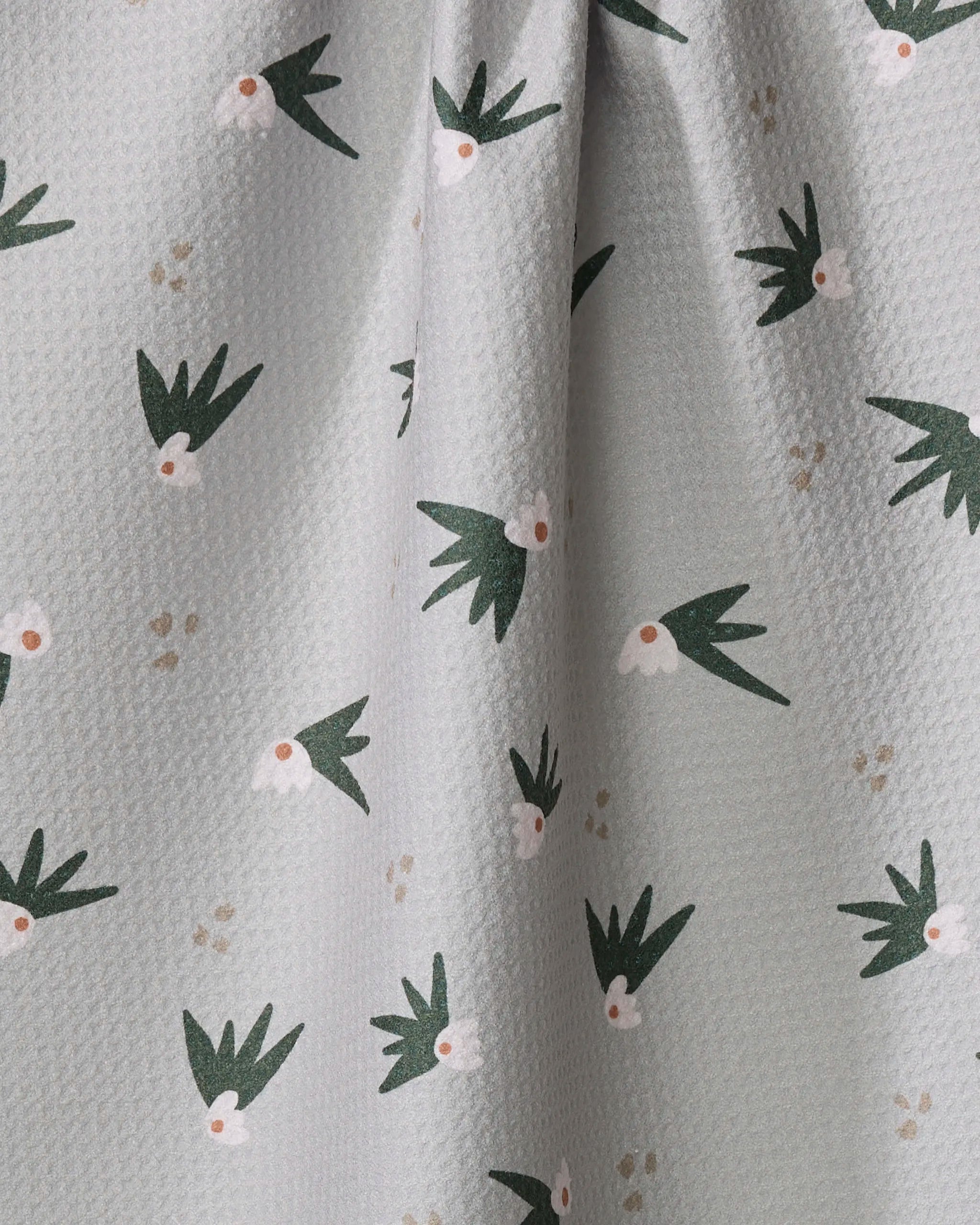 The Cali Sun Agave kitchen towel by Amberleigh Adoff features textured light gray recycled fabric, adorned with a charming repeating pattern of simple green birds with white and orange faces.