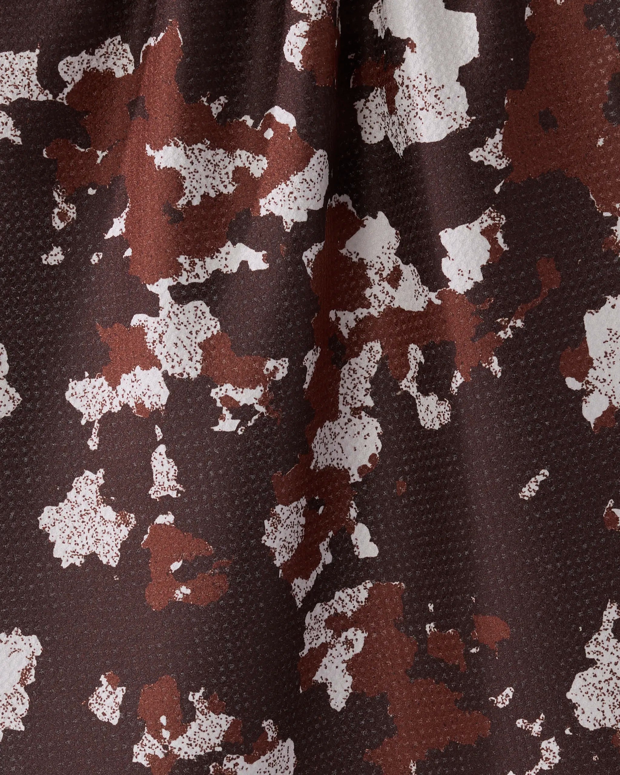 Close-up of Geometry’s Canyon Rose tea towel, showcasing a brown and white abstract camouflage pattern with textured, ultra-absorbent surface and varied color intensity.