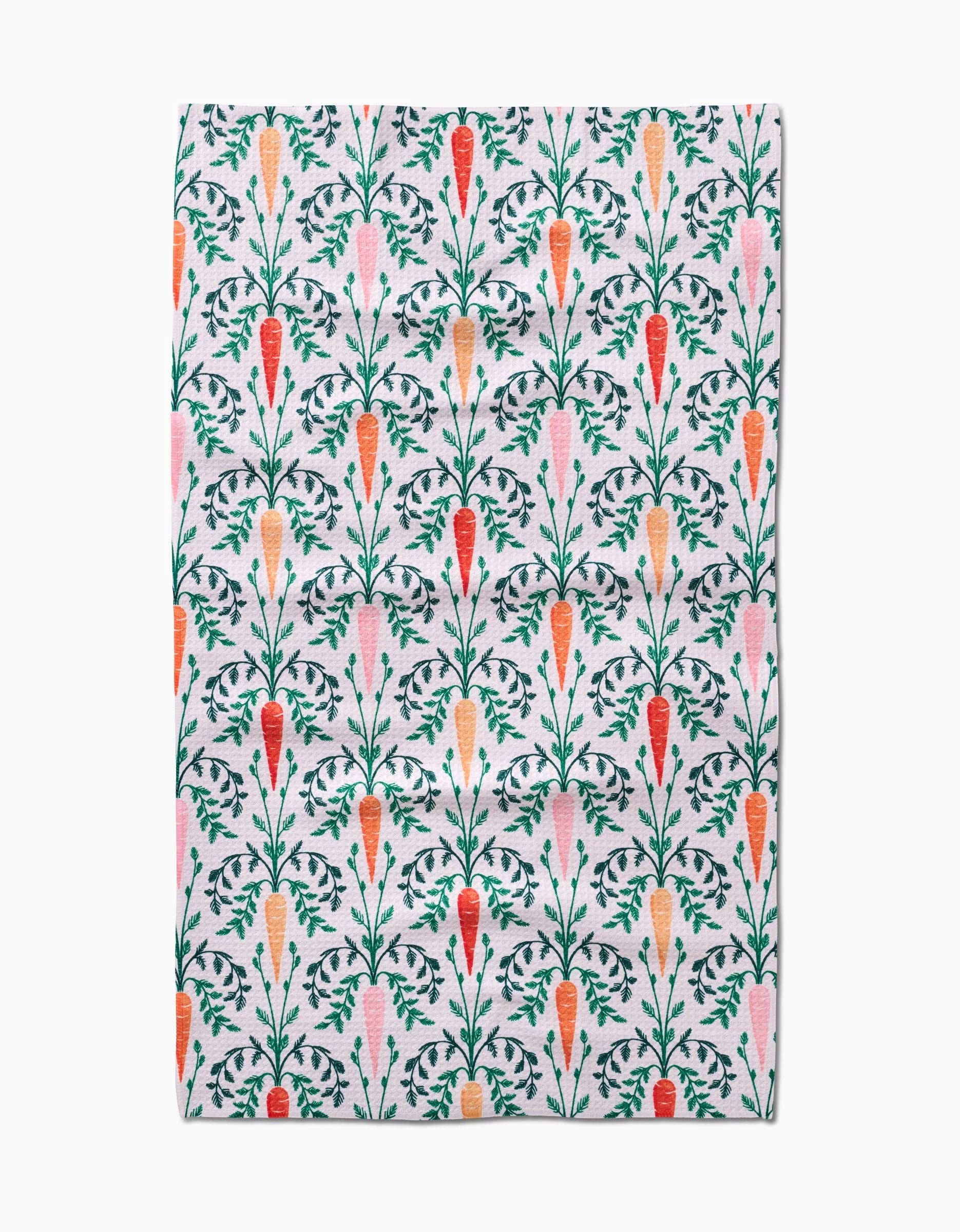 The Carrot Damask tea towel by Sarah Daugherty features a vertical carrot pattern in orange, red, and pink with green leaves on white. Made from absorbent recycled materials.