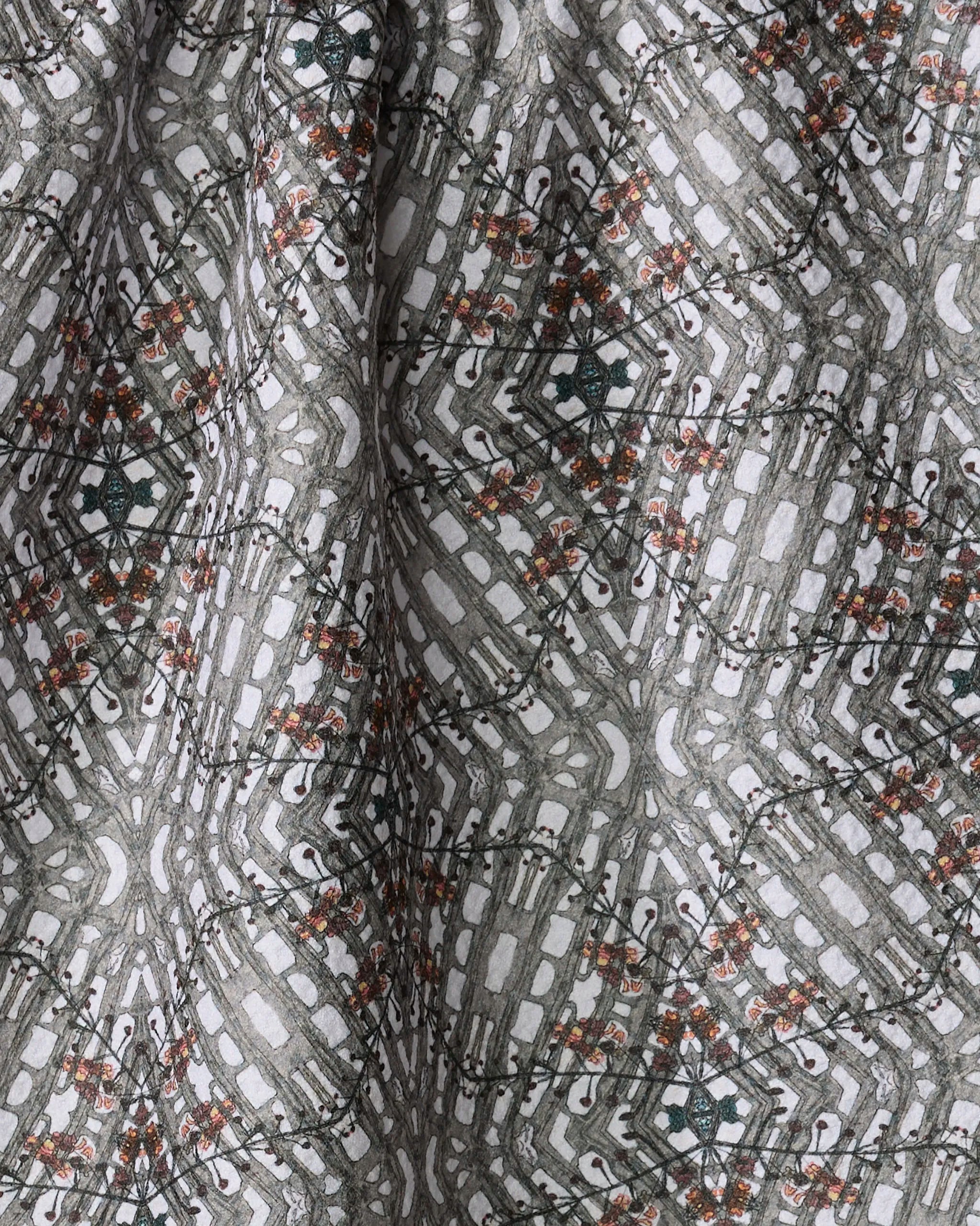A close-up of the Katherine Berkeley Cha Cha Interchange tea towel, made from recycled materials, featuring a geometric diamond pattern with gray, white, black, and orange accents. The quick-drying fabric is slightly folded.