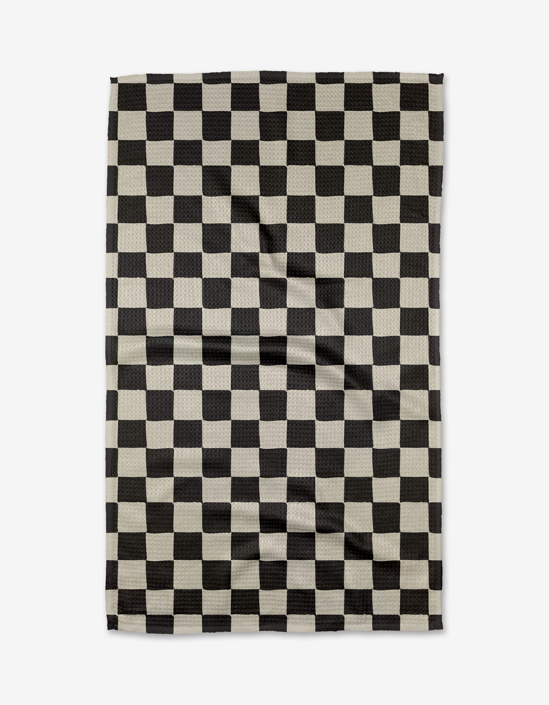 The Checkmate tea towel by Danelys Sidron features a black and white checkered design, shown flat with natural creases, and is crafted from recycled materials.