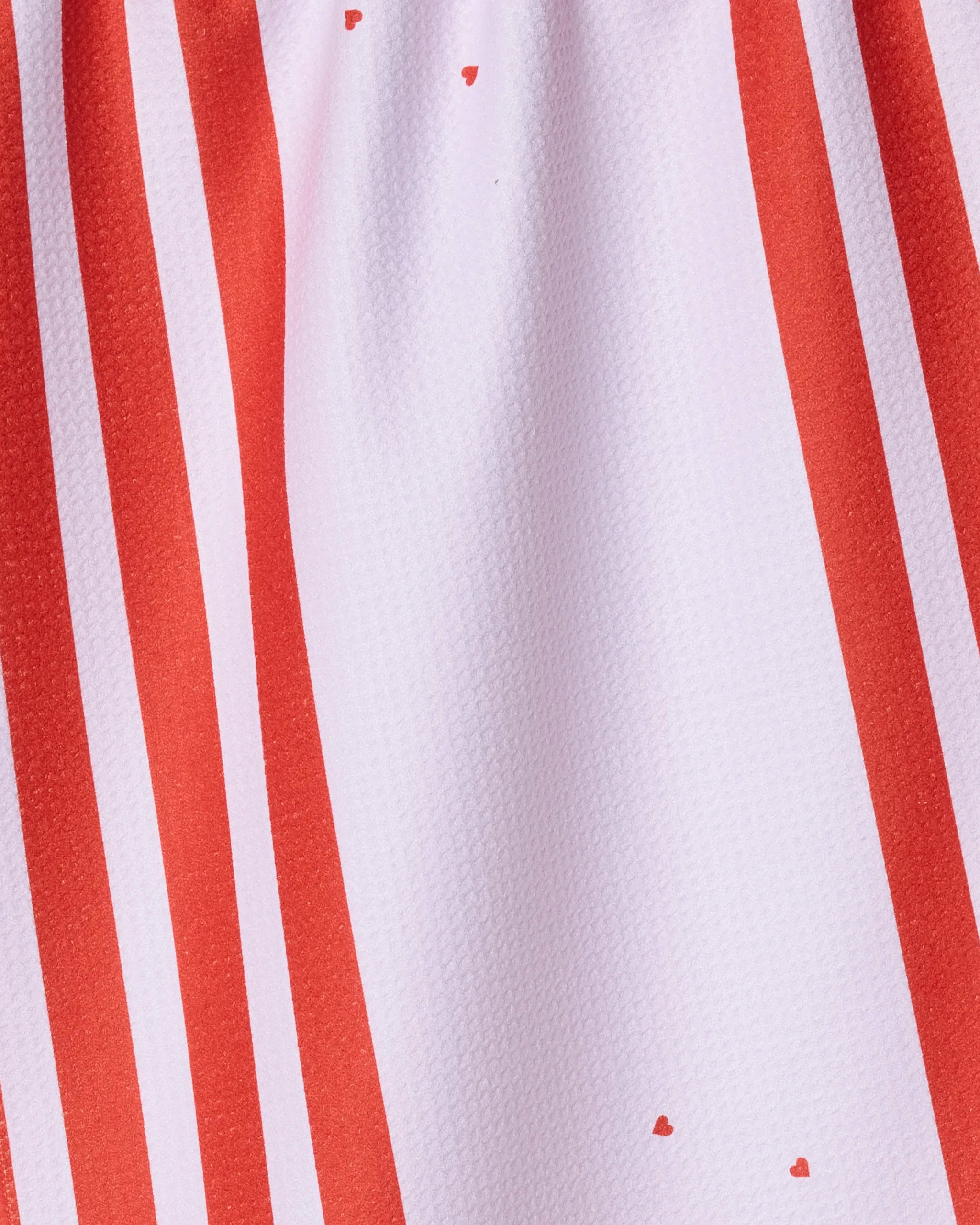 Close-up of the "Cheers My Dears" tea towel by Geometry, made from recycled materials and featuring vertical red and white stripes with small red spots on a slightly textured surface.