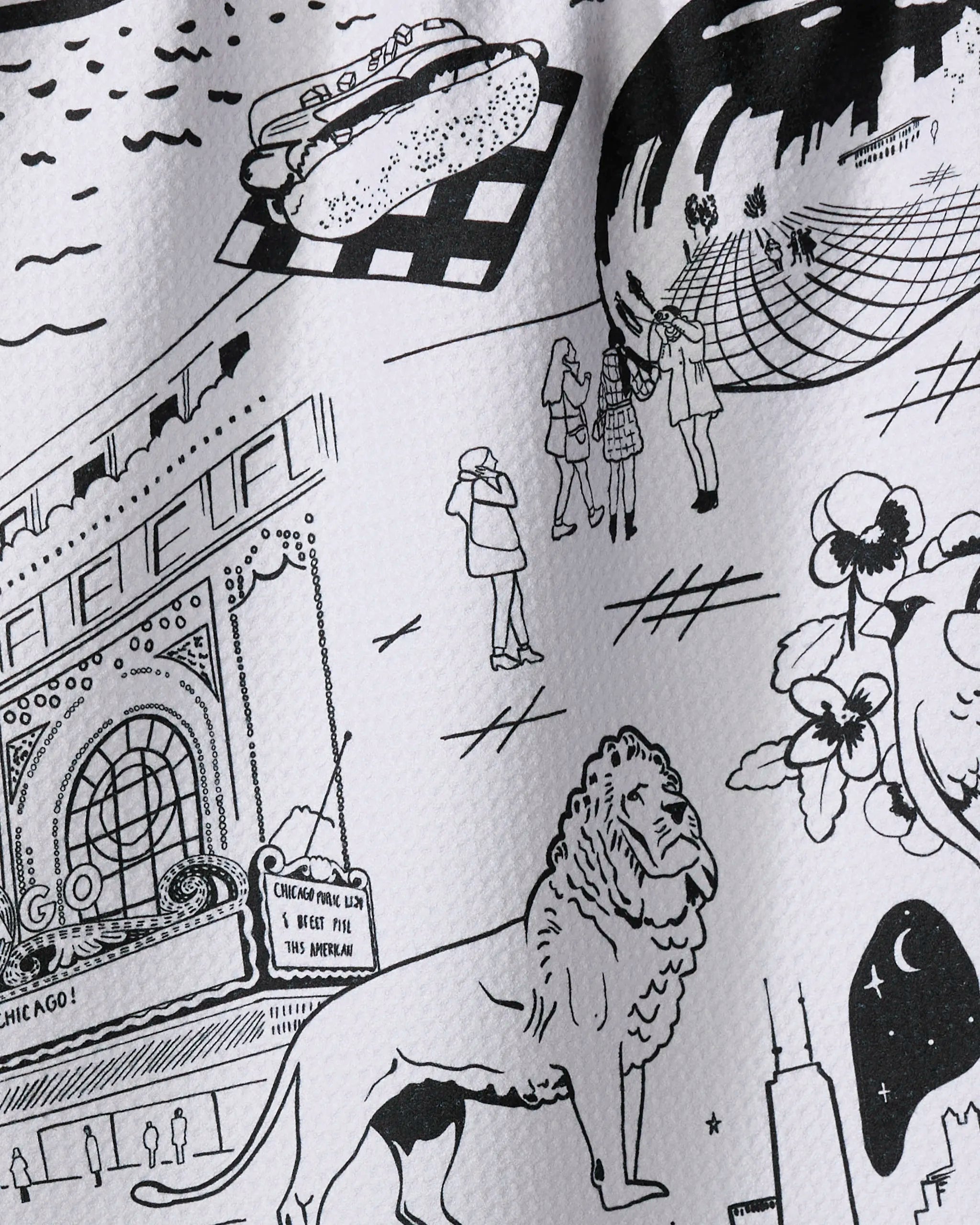 The "Chicago" kitchen towel by Elisabeth Wing features black and white sketches of city landmarks like the Bean, lion statue, Willis Tower, hot dog, and theater marquee—printed on recycled materials.