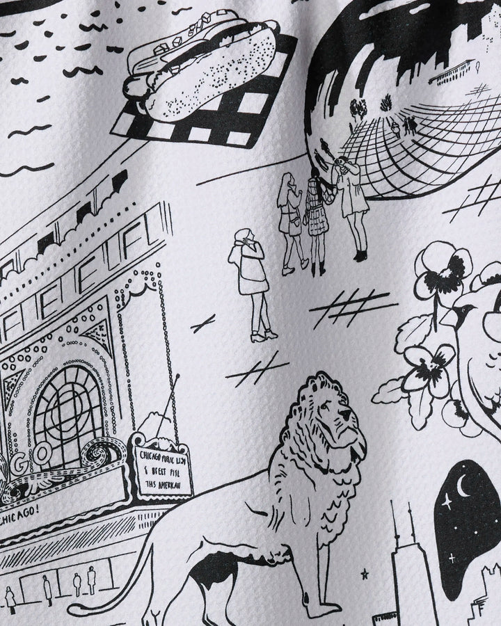 The "Chicago" kitchen towel by Elisabeth Wing features black and white sketches of city landmarks like the Bean, lion statue, Willis Tower, hot dog, and theater marquee—printed on recycled materials.