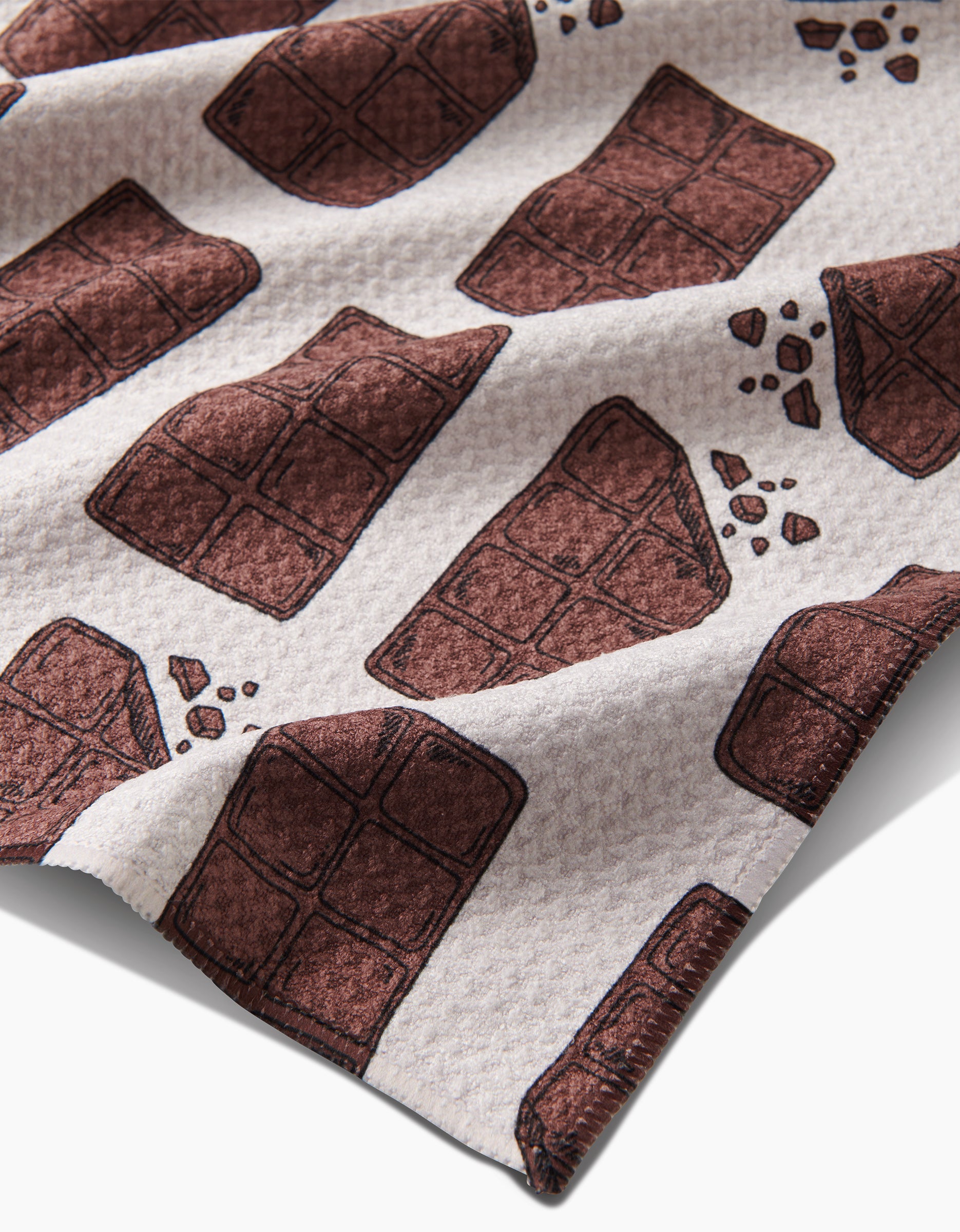 The Chocolate Everything tea towel by Amy Droubay is made of white Geoweave fabric and features a textured surface with playful illustrations of chocolate bars and pieces scattered across the design.