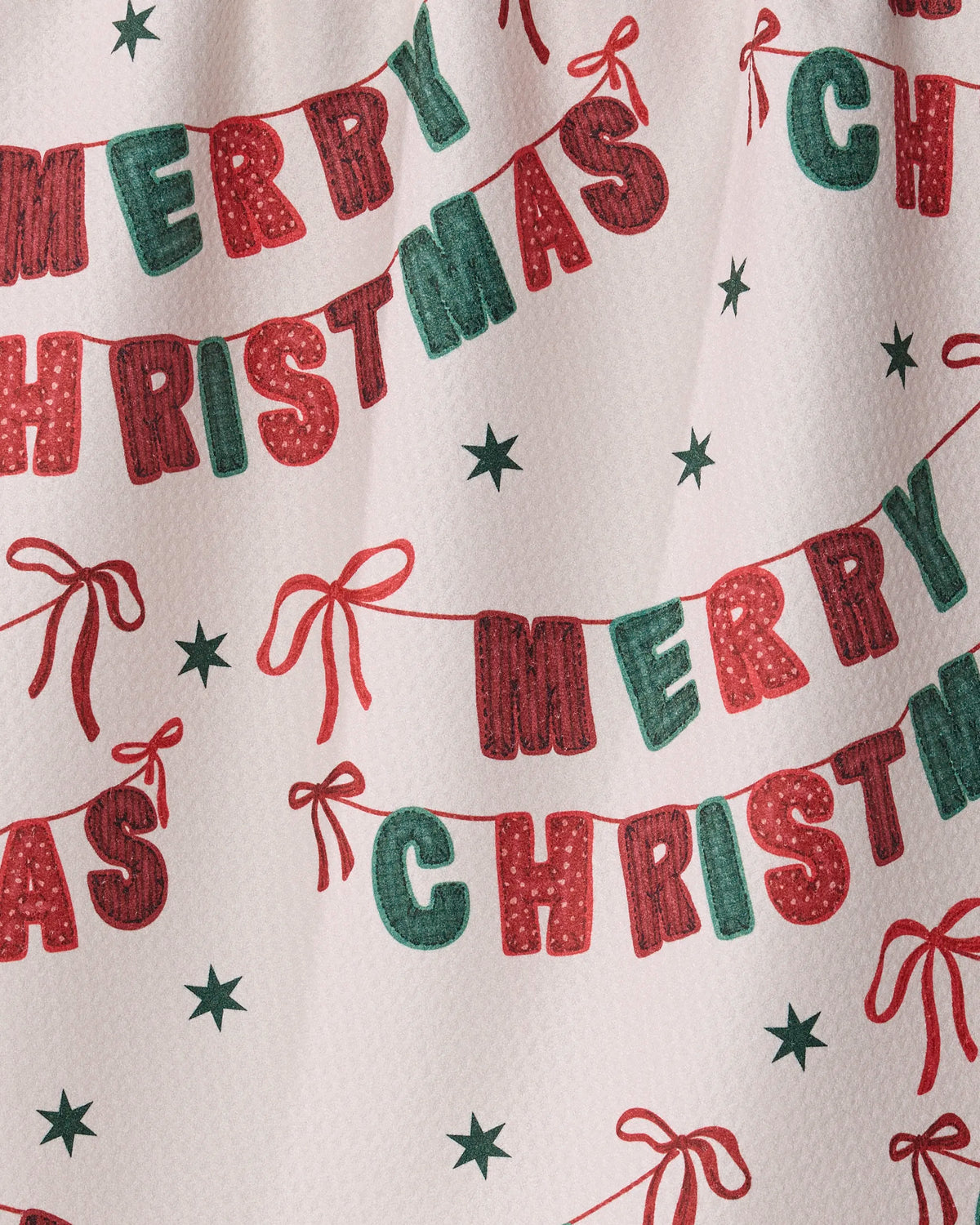 Add festive cheer to your tea towel collection with the Christmas Banner kitchen towel from Geometry. Featuring red and green letters spelling “Merry Christmas,” accented by red bows and green stars on a white textured background, this joyful holiday pattern is crafted from recycled materials—a sustainable and stylish addition to your kitchen.