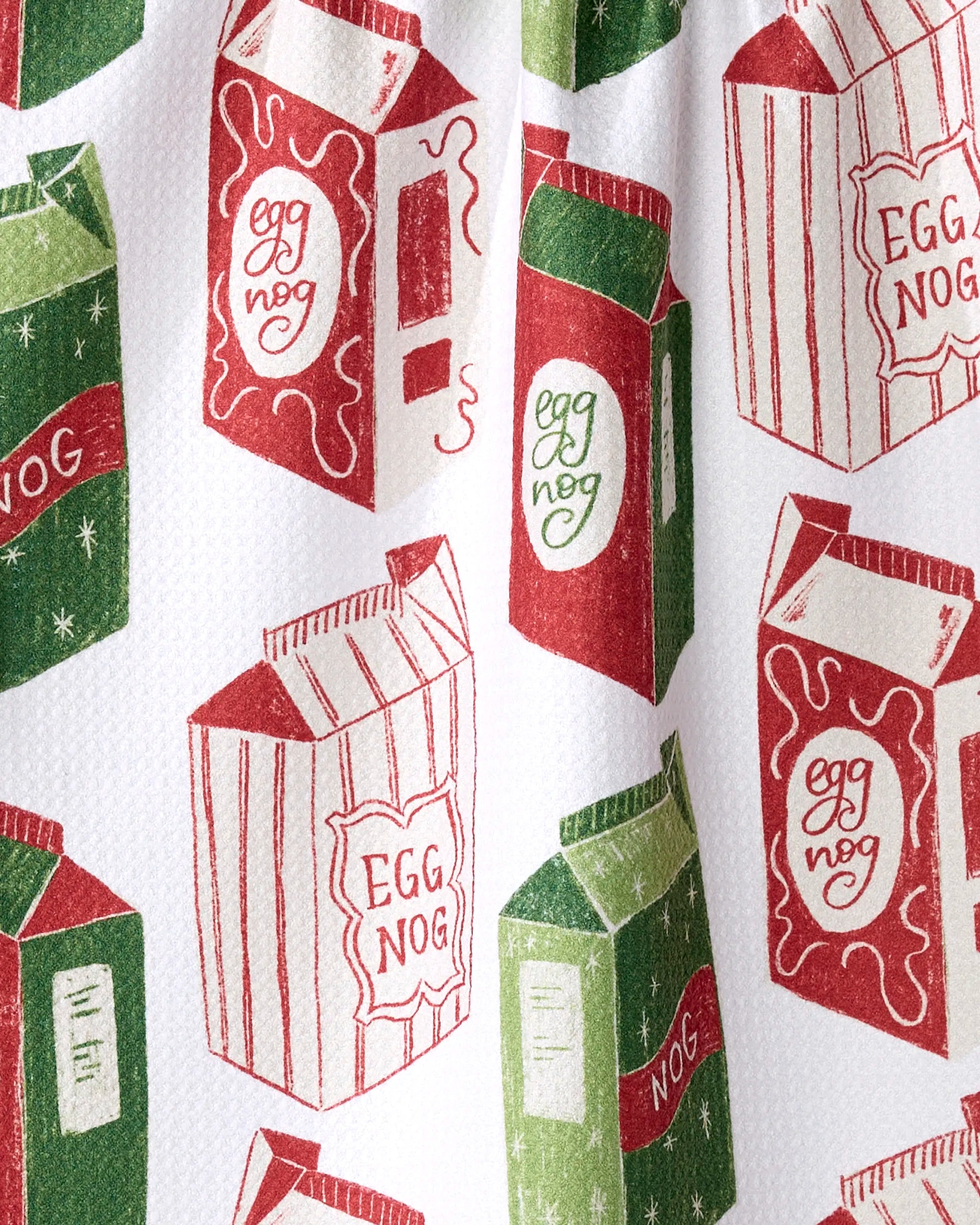 Aubrey Fairchild’s Christmas Eggnog design features green and red cartons labeled “Eggnog” on white, with vintage illustrations—ideal for an eco-friendly kitchen or ultra-absorbent tea towel.