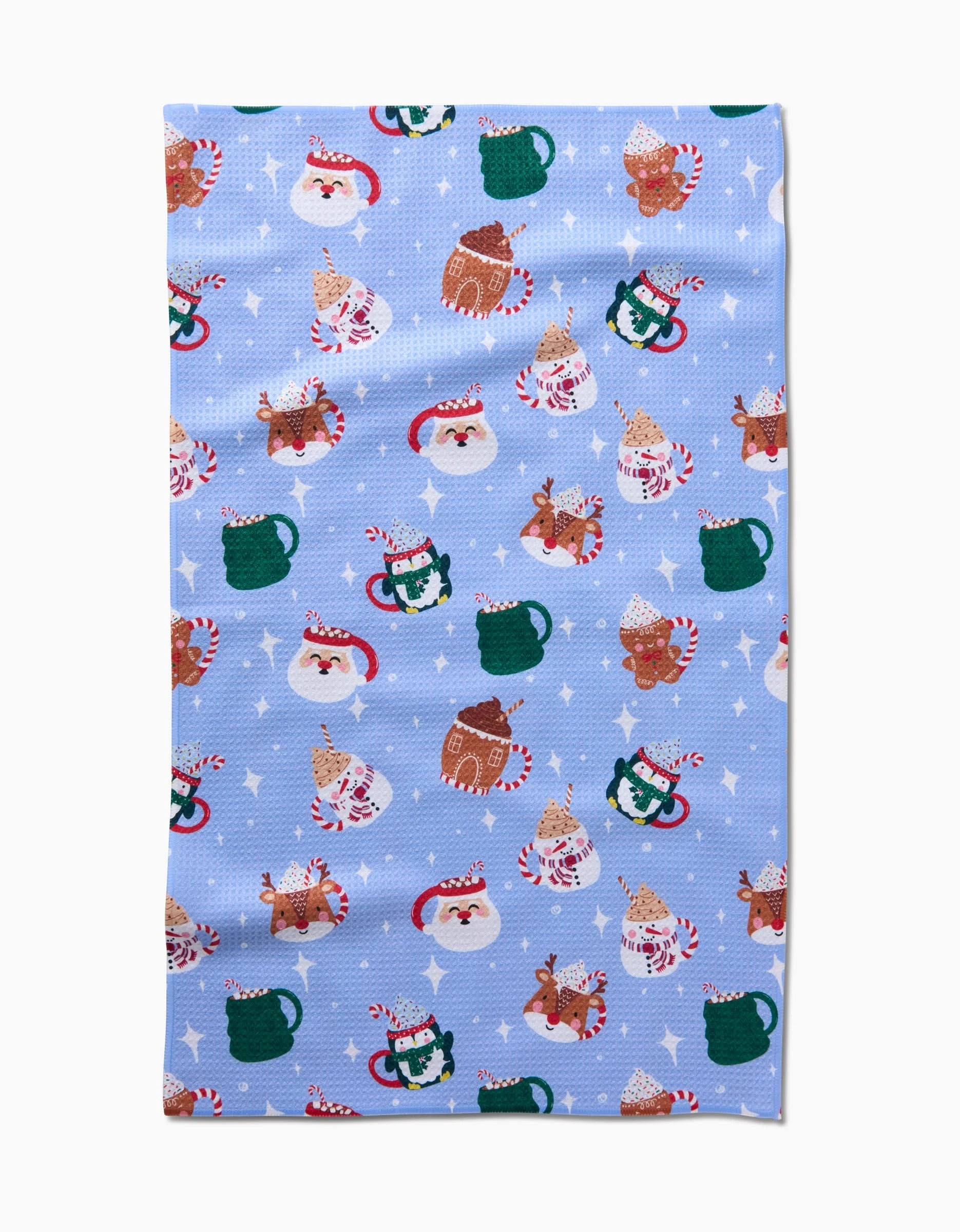 The Christmas Mugs tea towel by Vaishali Design Studio features a festive blue pattern with cats in Santa hats, mugs, candy canes, and stars—crafted from recycled fabric for an eco-friendly holiday accent.