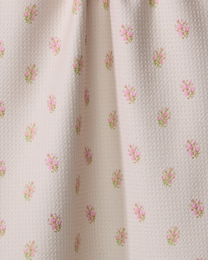 Close-up of Cindy by Kelsi Fullmer—an ultra-absorbent white fabric softly gathered in the center, featuring a repeating pattern of small pink rose bouquets and green leaves, perfect for a charming tea towel.
