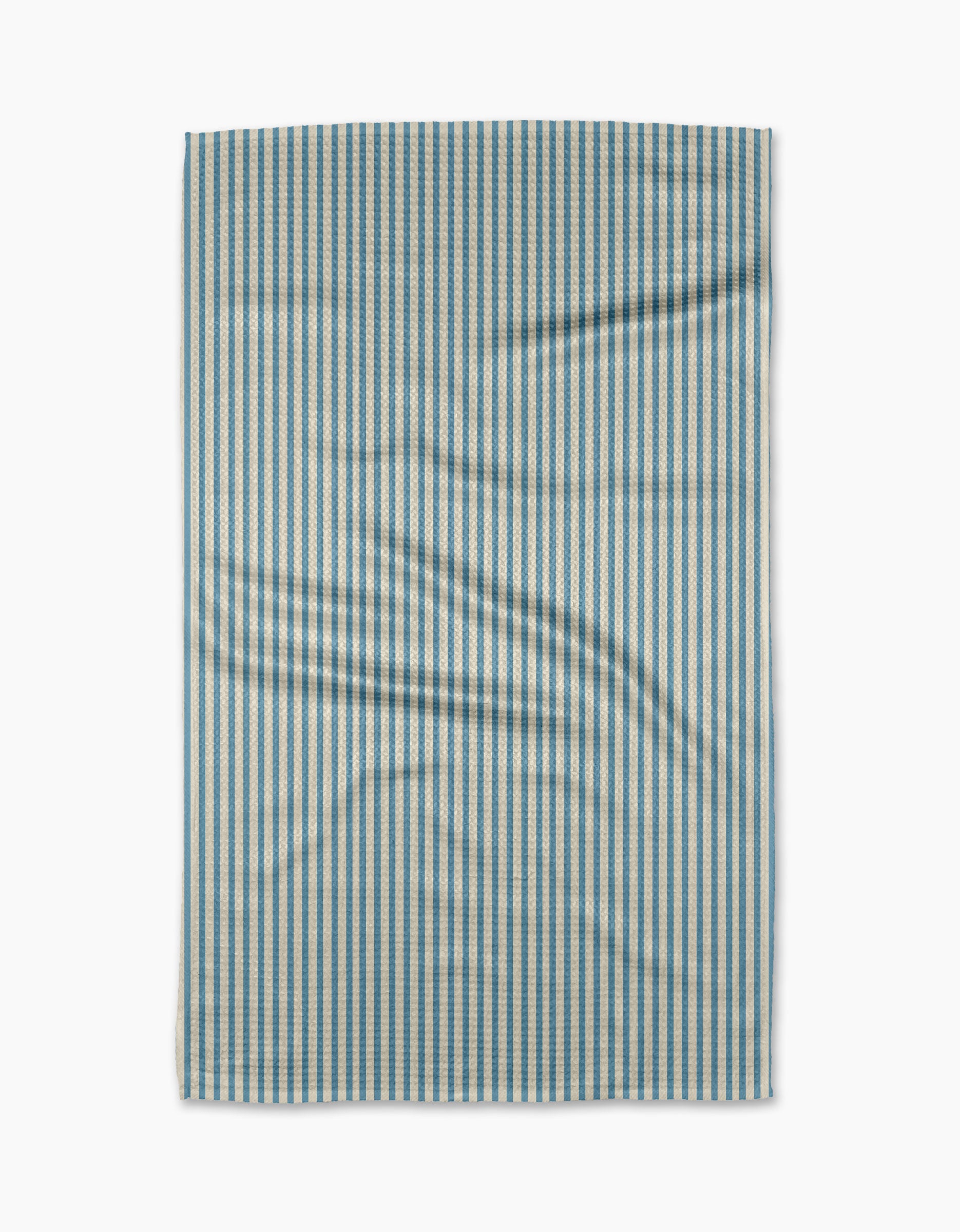 The Clean Slate tea towel by Susan Heid is rectangular, made from recycled materials, with thin blue and white vertical stripes and a slightly wrinkled texture, shown against a white background.