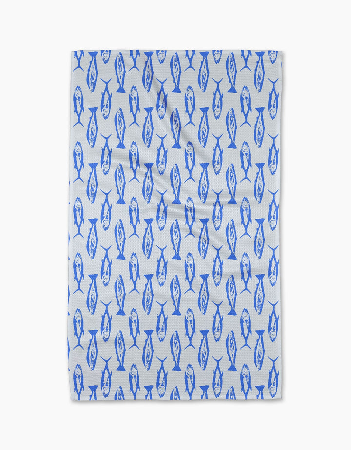 The Geometry Coastal Catch Tea Towel, made from Geoweave fabric, features a repeating blue fish pattern and is shown flat against a plain white background.