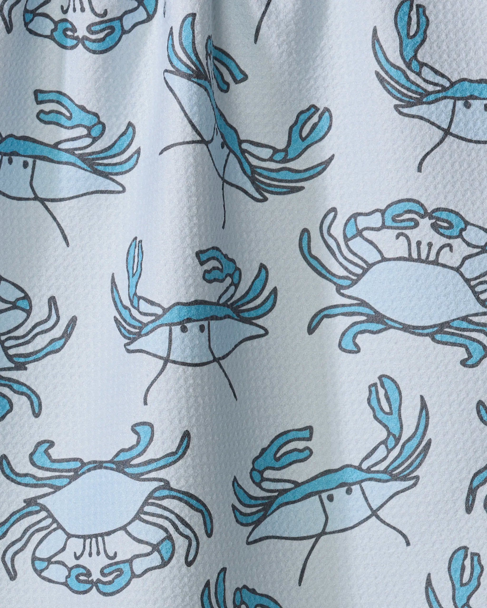 The Mindfulnice "Coastal Crew" tea towel features a white textured fabric with blue crabs outlined in black, each with two raised claws and simple faces, printed in various directions on quick-drying recycled materials.