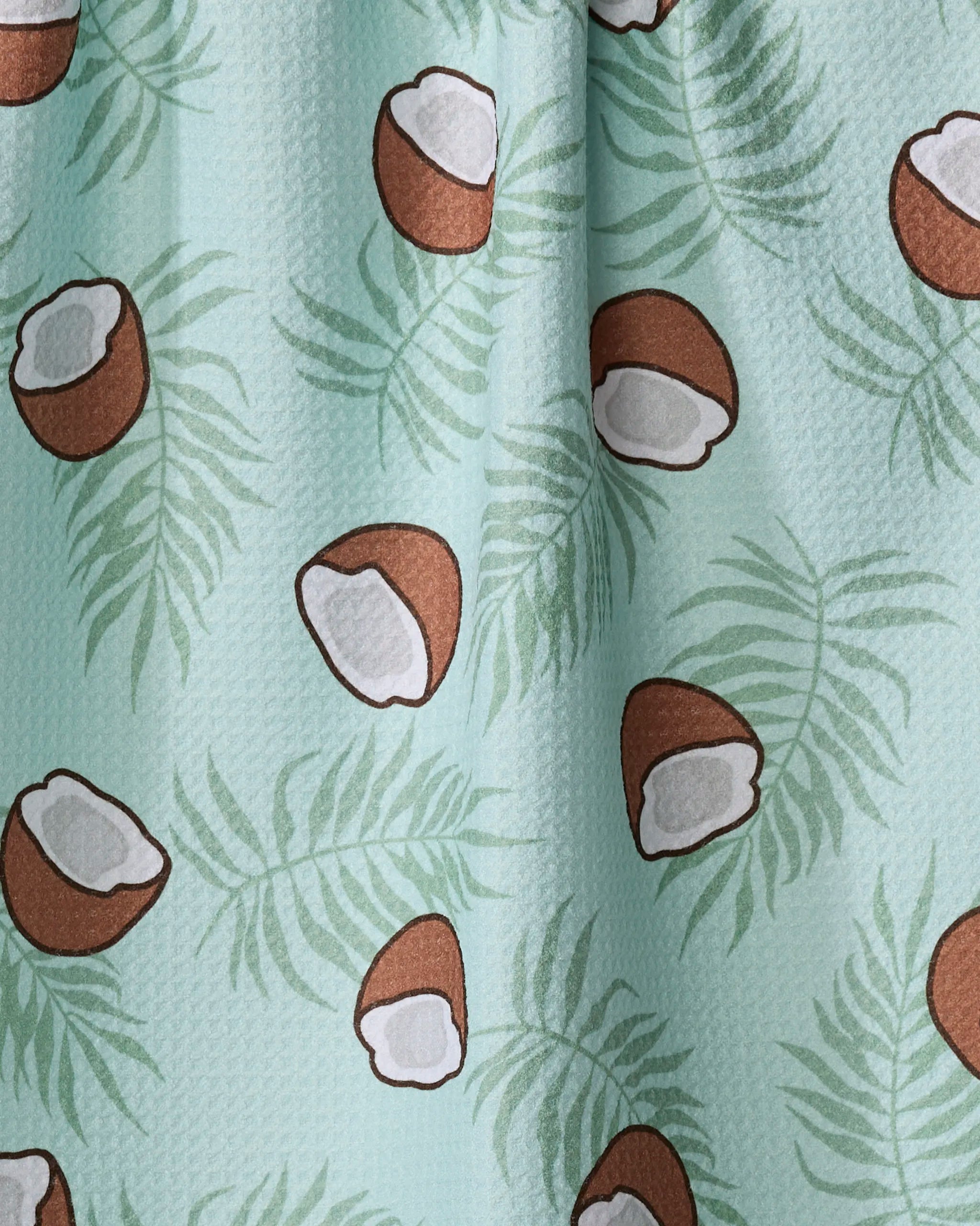 Purely Kaylie's Coconut Waves tea towel features light green Geoweave fabric with a textured palm leaf pattern and scattered brown coconuts with white interiors.