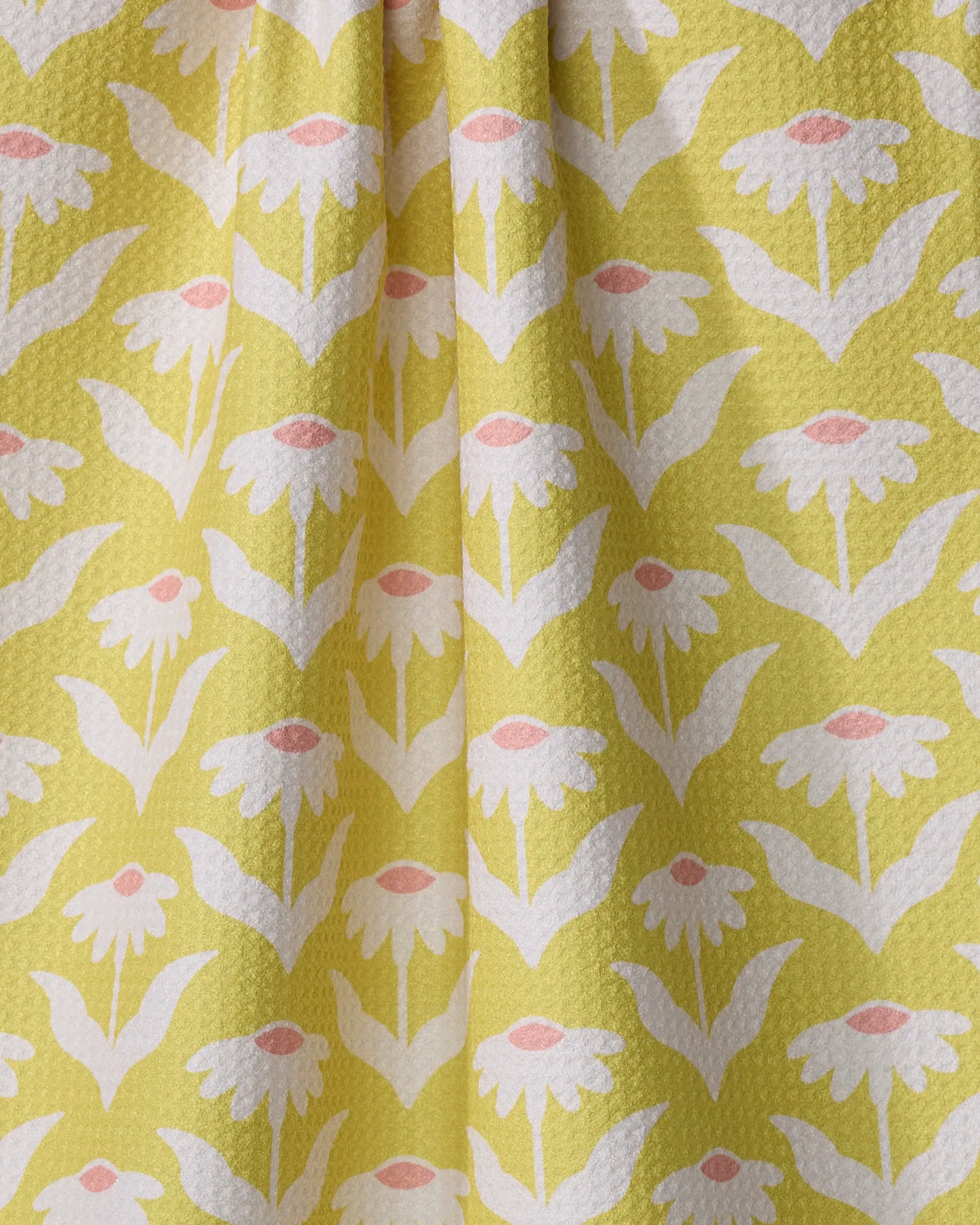 Coneflower by Kayla Ann: a recycled kitchen towel with yellow fabric, white daisies, green leaves, and pink centers. With slight folds and a textured surface, it brings cheerful style to any space.