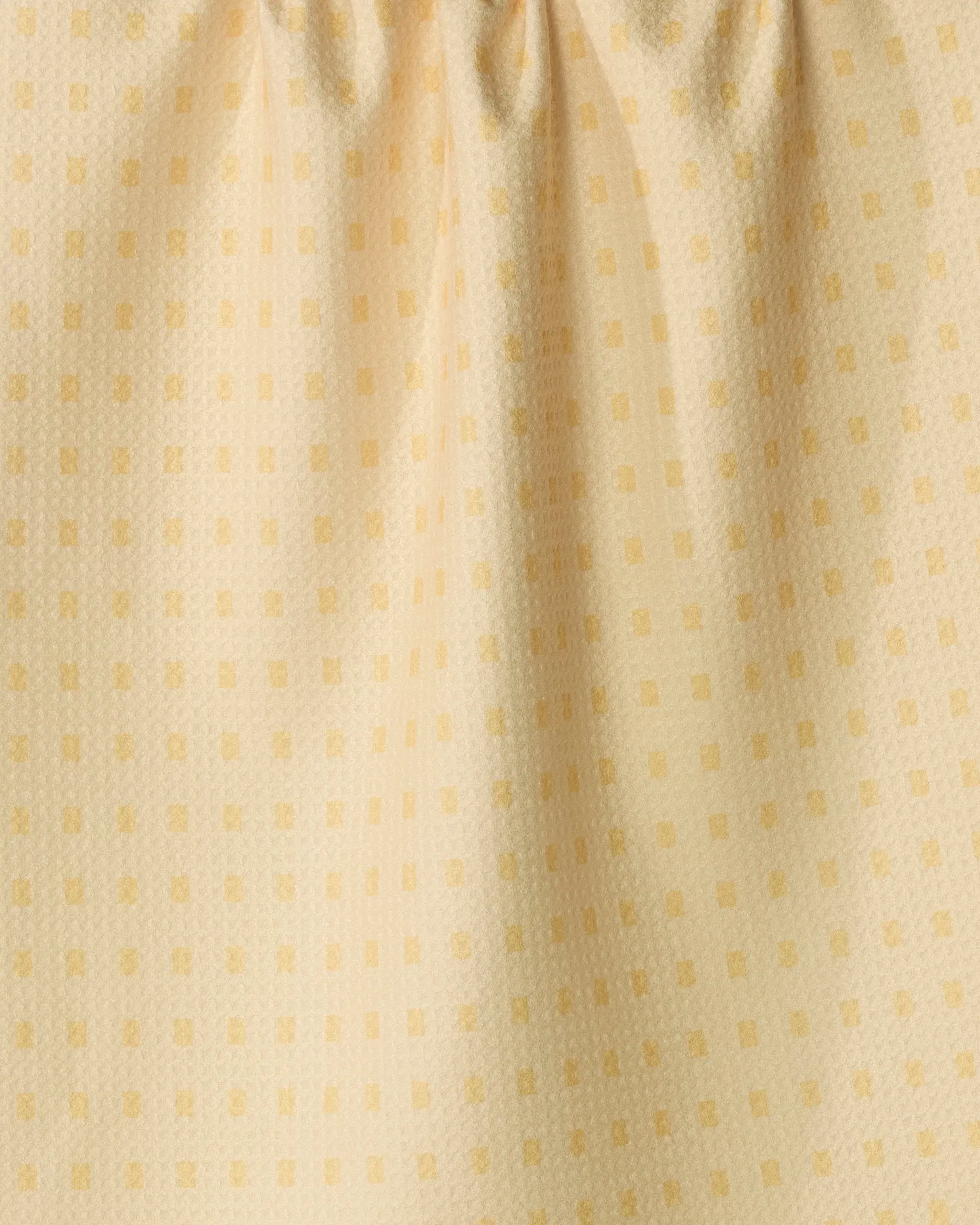 Close-up of the eco-friendly Geometry kitchen towel in the Confetti Tiles design, featuring a subtle grid pattern of small, evenly spaced squares and soft folds at the top that create gentle vertical lines.