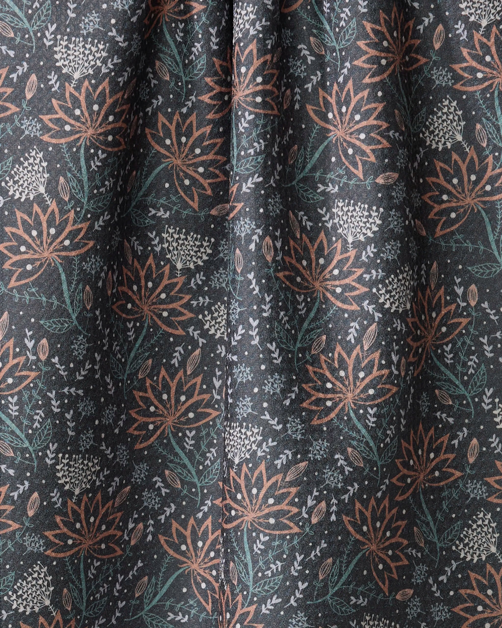 Coral Blooms by Amita Nair is a dark tea towel with orange and white floral patterns, green leaves, and small branches. Made from ultra-absorbent recycled fabric gathered at the center for an elegant look.
