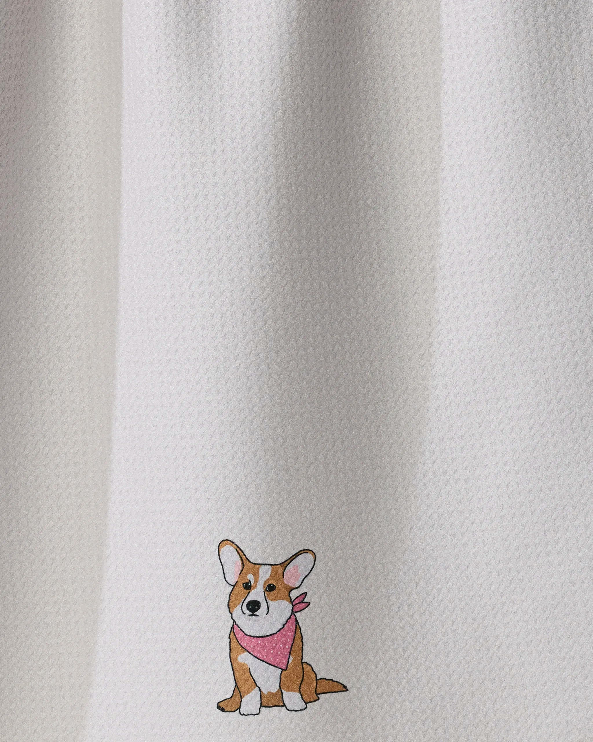 A small illustration of a brown and white corgi wearing a pink bandana appears in the bottom corner of the textured white Geometry Corgi Charm kitchen towel.