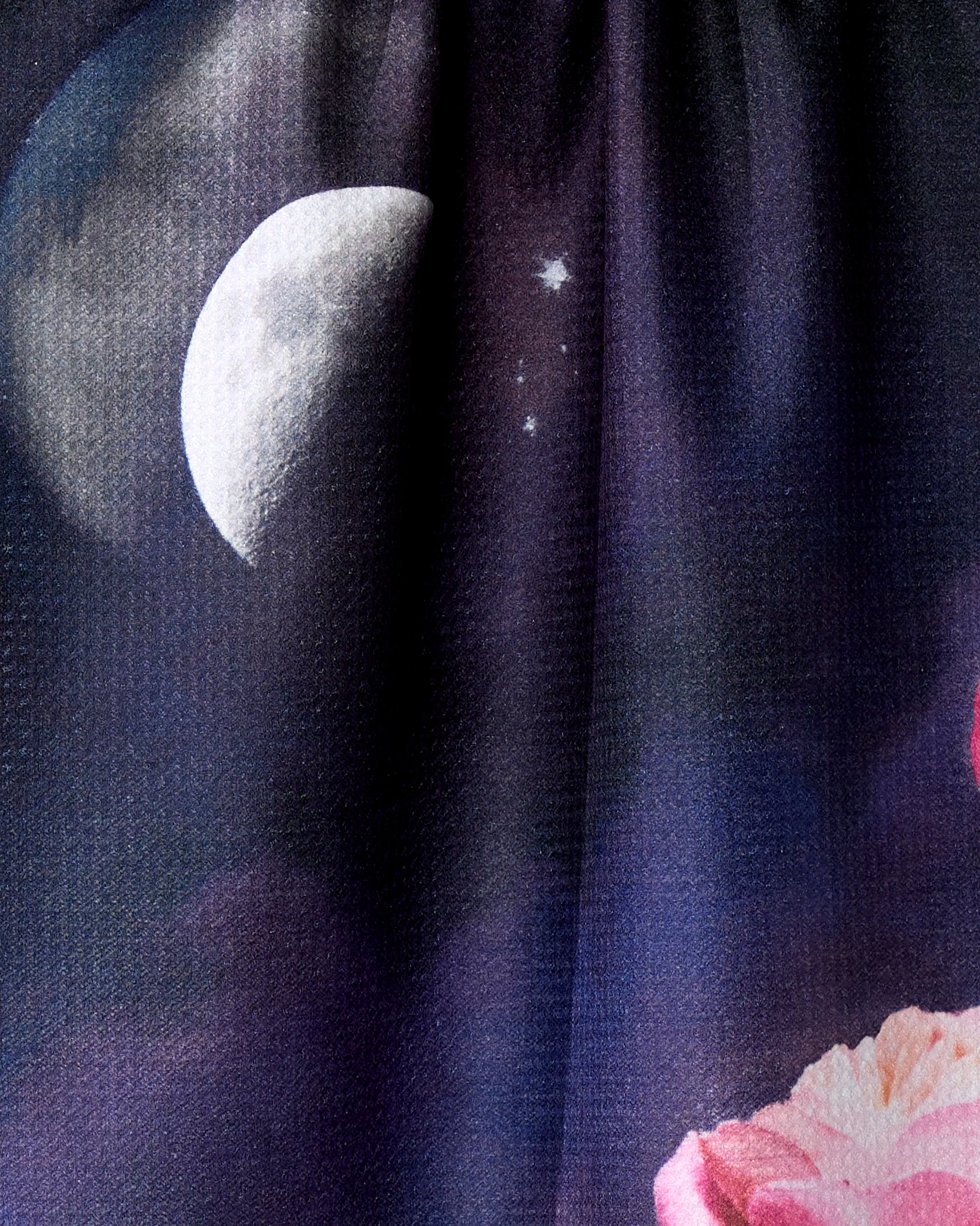 A close-up of Stefanie Bales’ Counterglow: an ultra-absorbent kitchen tea towel featuring a crescent moon, stars, dark night sky, and pink roses printed in the lower right corner.