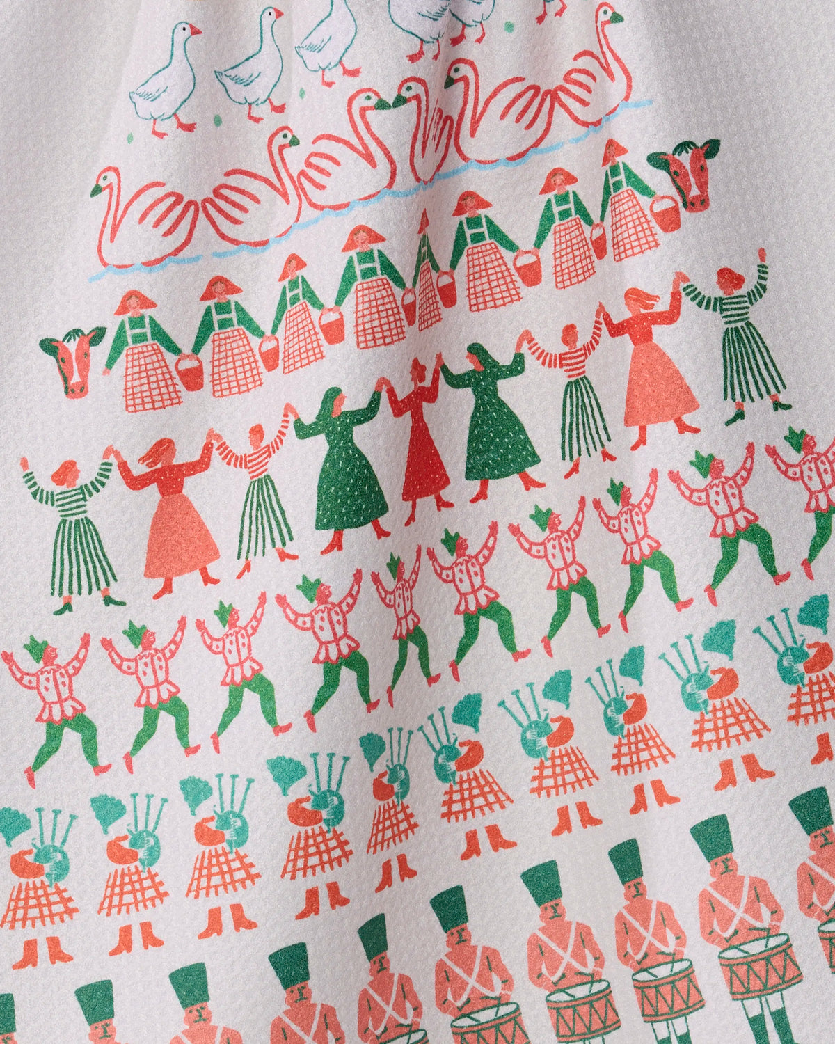 Introducing the Counting Christmas tea towel by Geometry: featuring a vibrant illustration of dancers, drummers, geese, and swans in playful rows inspired by the Twelve Days of Christmas song, this festive towel is printed on textured white fabric and crafted from quick-drying recycled materials—offering both sustainable charm and practical holiday cheer.