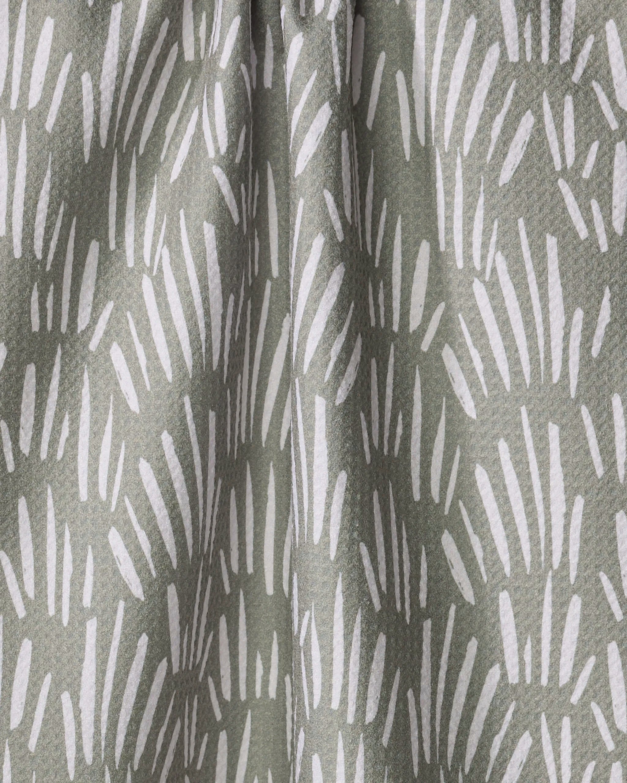 Close-up of Hufton Studio’s "Country Fields" kitchen towel, crafted from recycled materials and adorned with white, brushstroke-like shapes on a muted green background for a textured, abstract look.