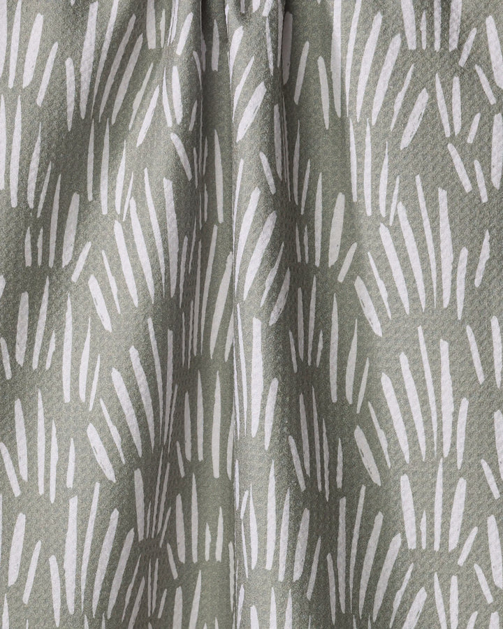 Close-up of Hufton Studio’s "Country Fields" kitchen towel, crafted from recycled materials and adorned with white, brushstroke-like shapes on a muted green background for a textured, abstract look.