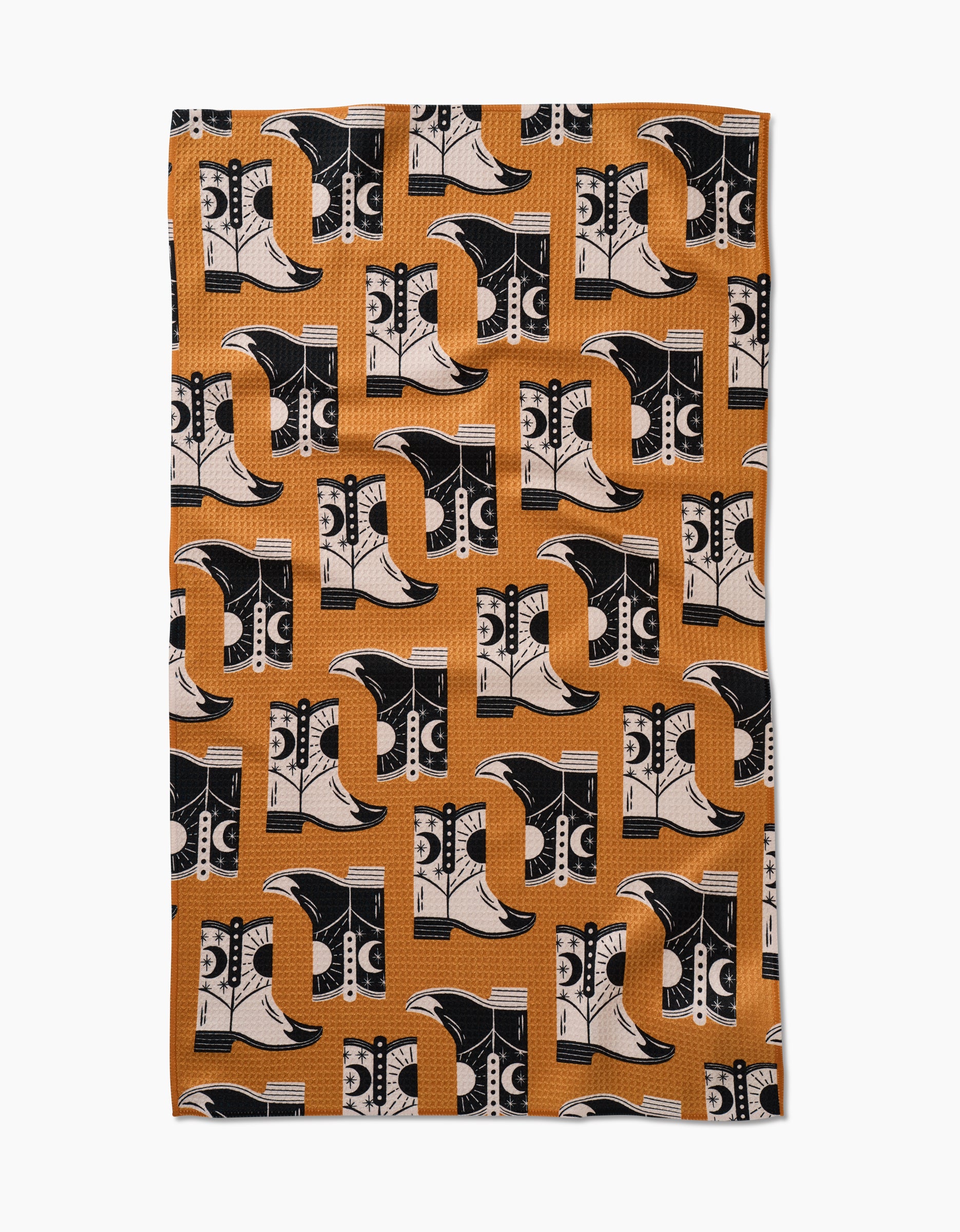 The Megan Roy Cowboy Boots towel features a patterned Geoweave fabric with alternating black and white cowboy boots on light brown, oriented in various directions for an ultra-absorbent finish.