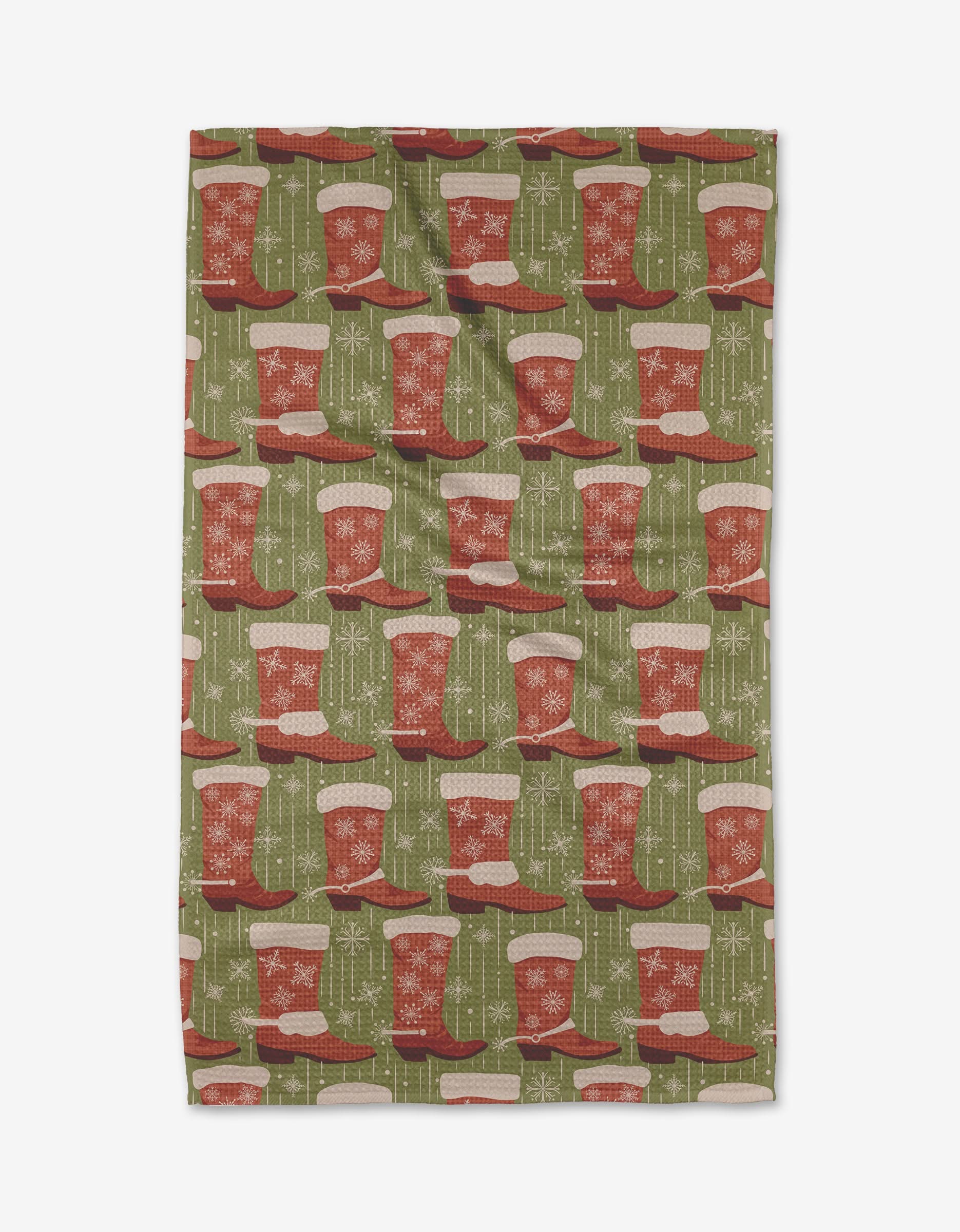 The Cowboy Stockings tea towel by Julianne Haness features a green background with red and white Christmas stockings, snowflakes, and geometric designs. Made from ultra-absorbent, recycled materials.