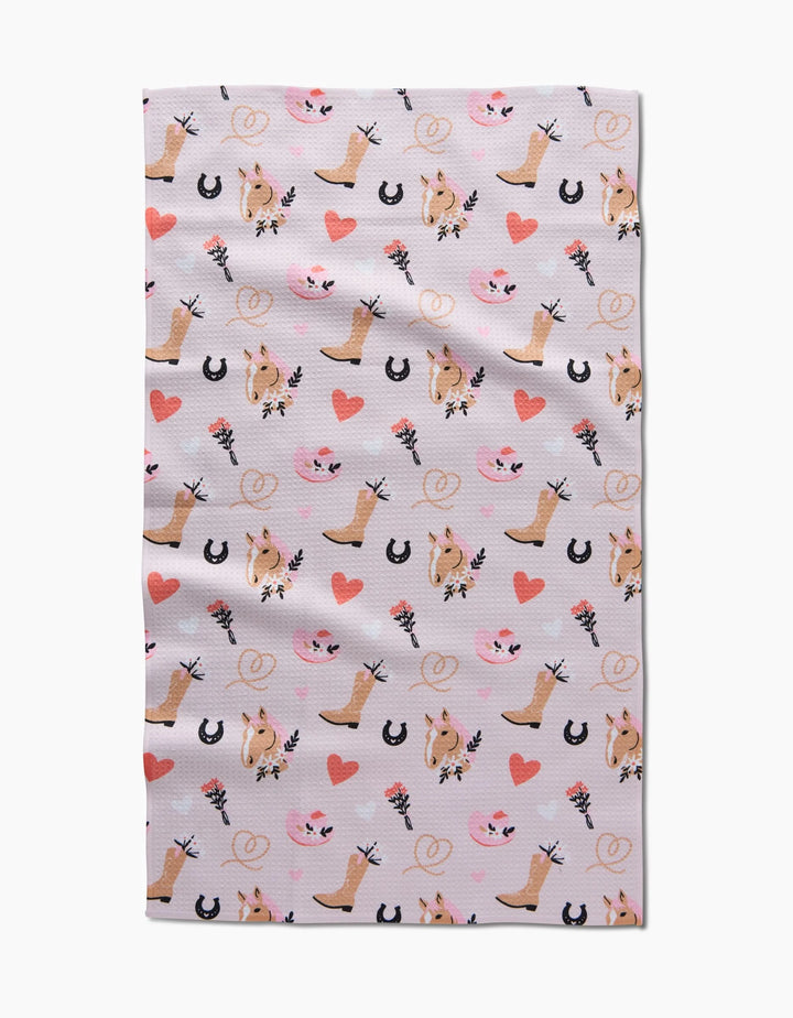 Cowgirl Love by Amberleigh Adoff: A repeating pattern of cowboy boots, horses, hearts, and lassos in pink, brown, and black on light—ideal for an eco-friendly, ultra-absorbent kitchen or tea towel.