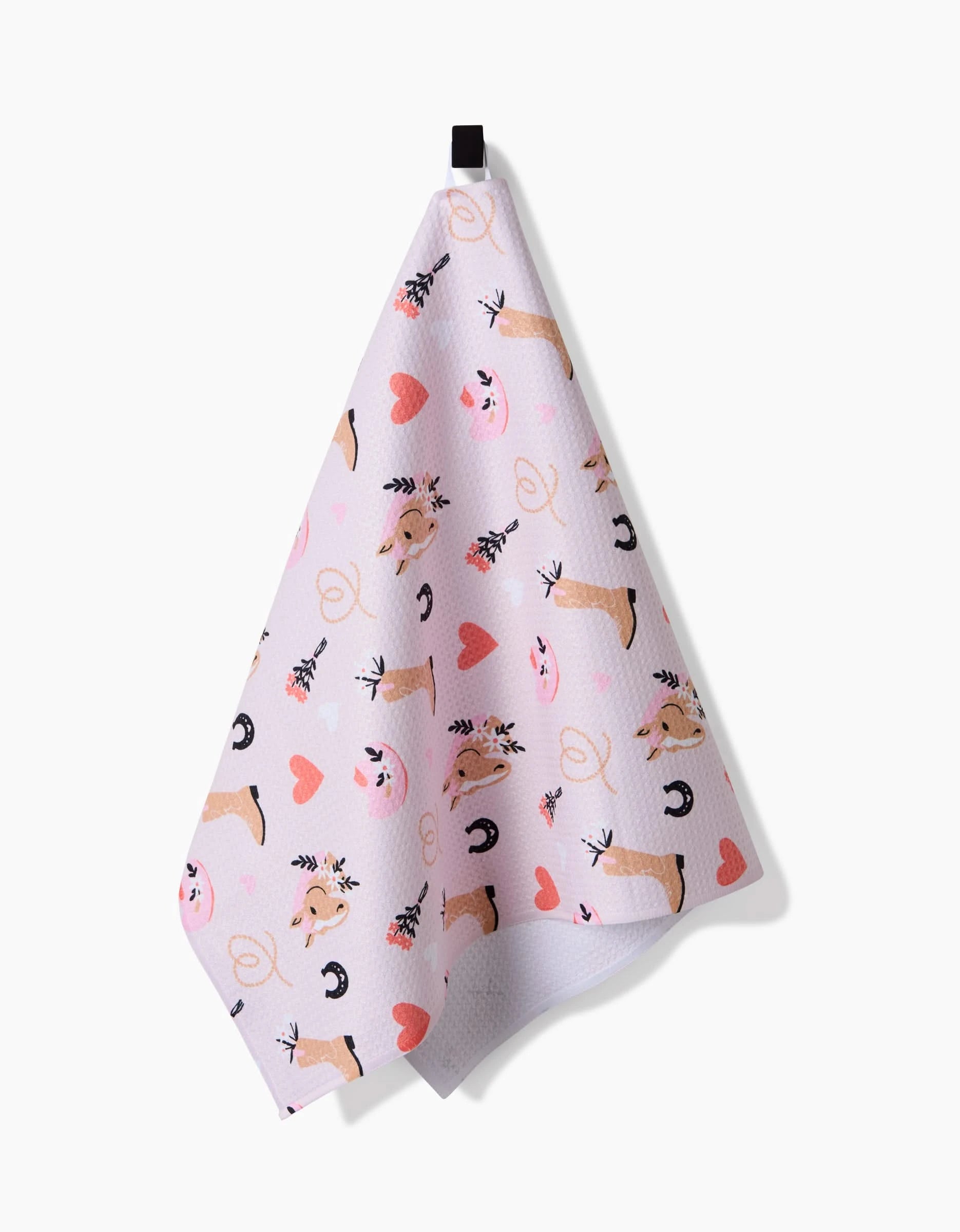 The Cowgirl Love tea towel by Amberleigh Adoff features pink and orange hearts, cartoon horseshoes, boots, lassos, and smiling pig faces—an ultra-absorbent, eco-friendly accent that adds charm to your kitchen.