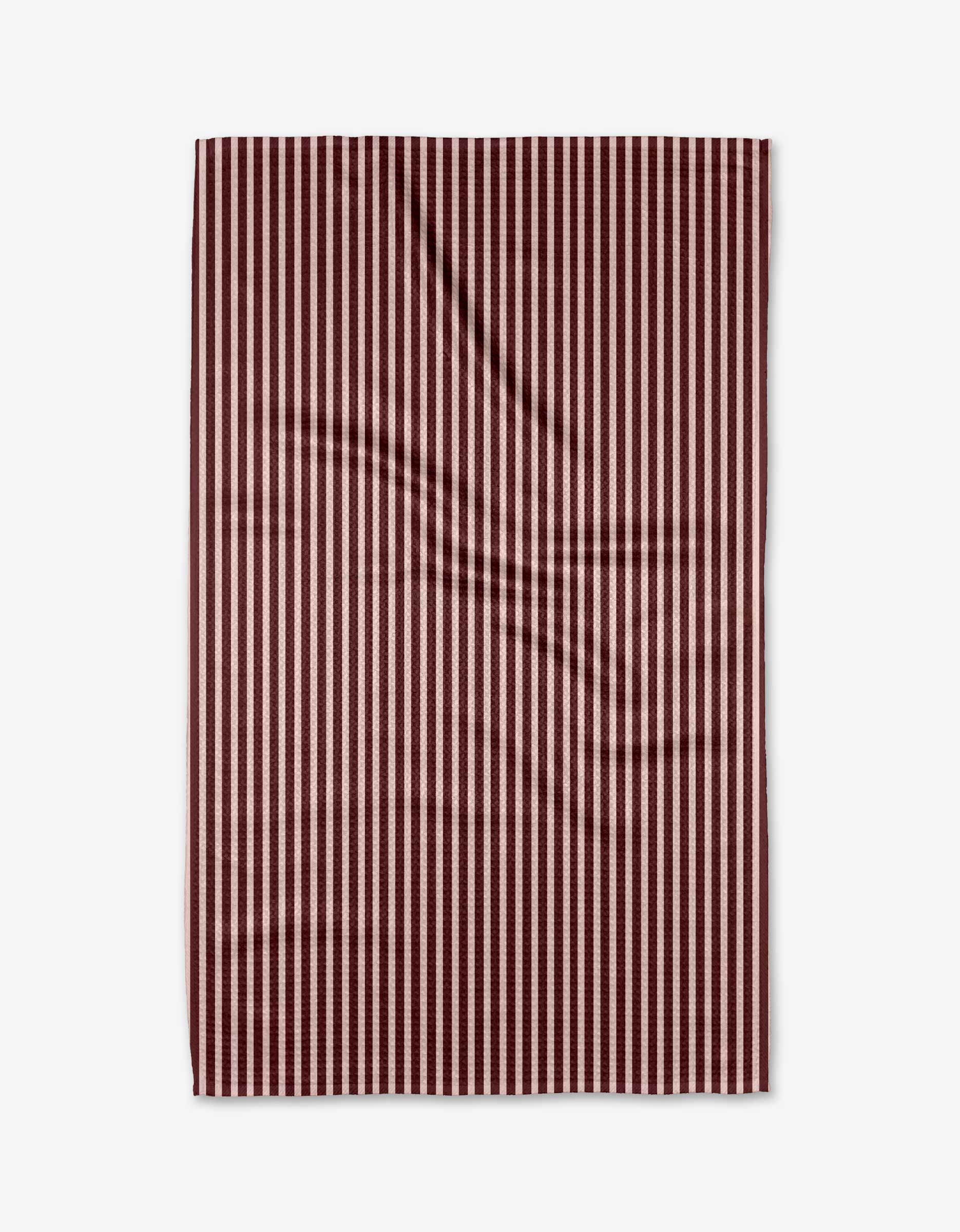 The Kelsi Fullmer Cranberry Stripe towel is rectangular, ultra-absorbent, and features vertical maroon and white stripes. It’s shown laid flat on a white background with minor creases visible.