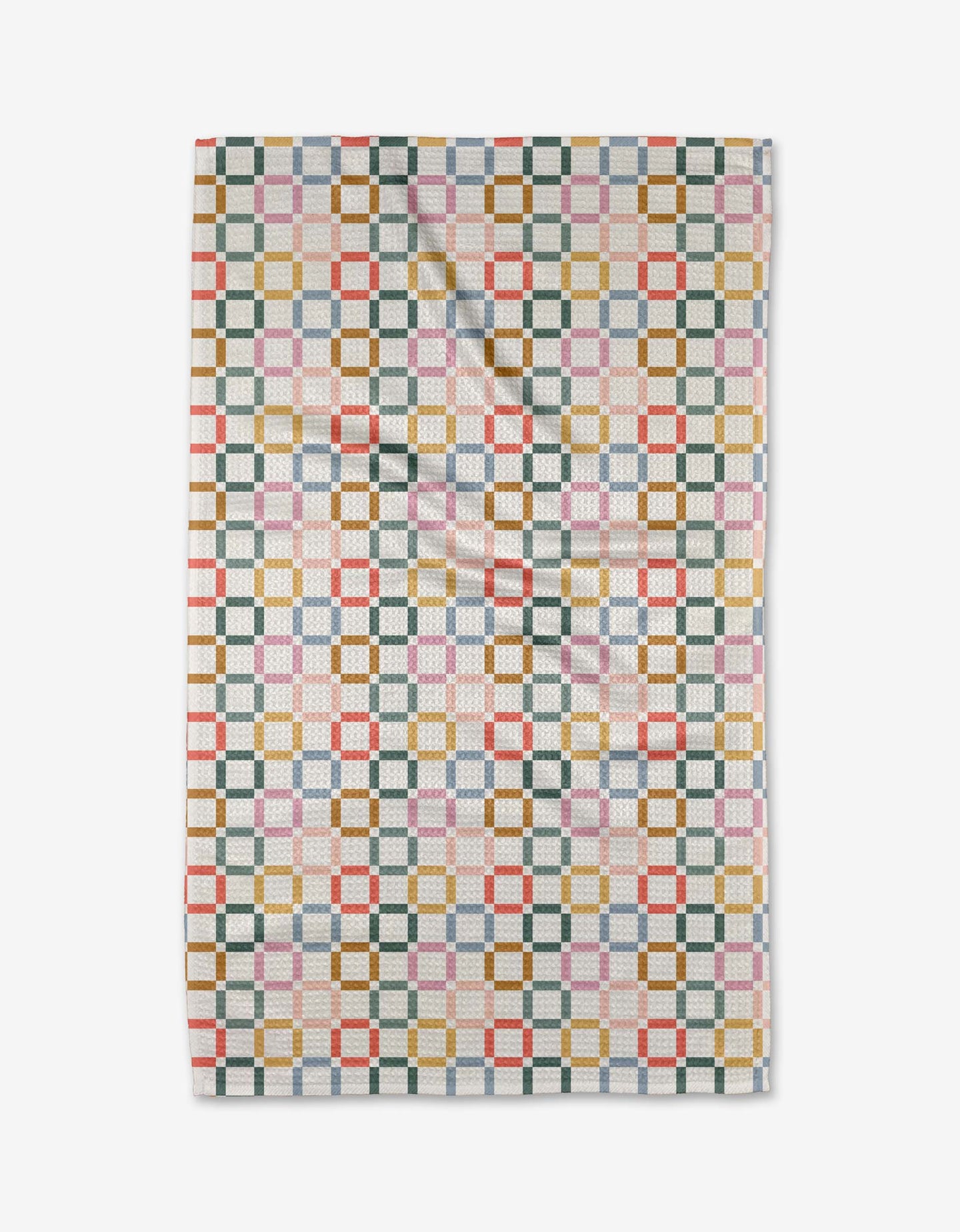 The Crossroads tea towel by Charlie Rowan Designs features a geometric pattern of interlocking squares in green, gold, red, blue, and pink on white Geoweave fabric, shown flat with slight folds.