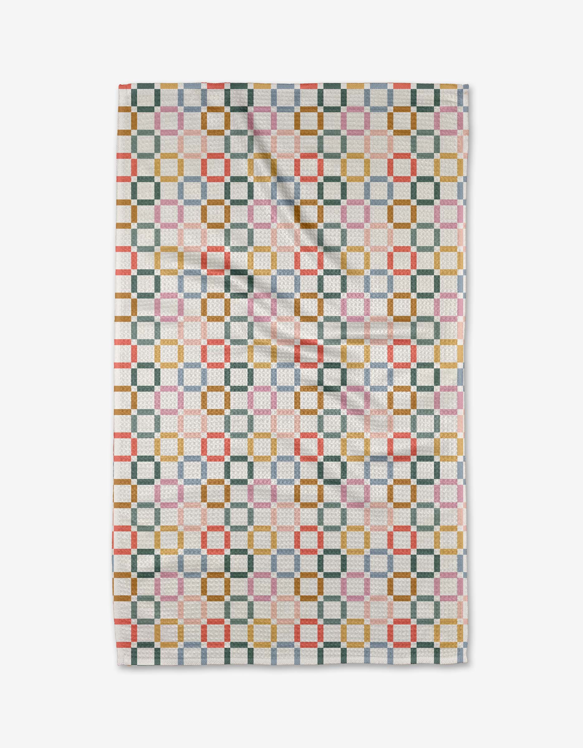 The Crossroads tea towel by Charlie Rowan Designs features a geometric pattern of interlocking squares in green, gold, red, blue, and pink on white Geoweave fabric, shown flat with slight folds.