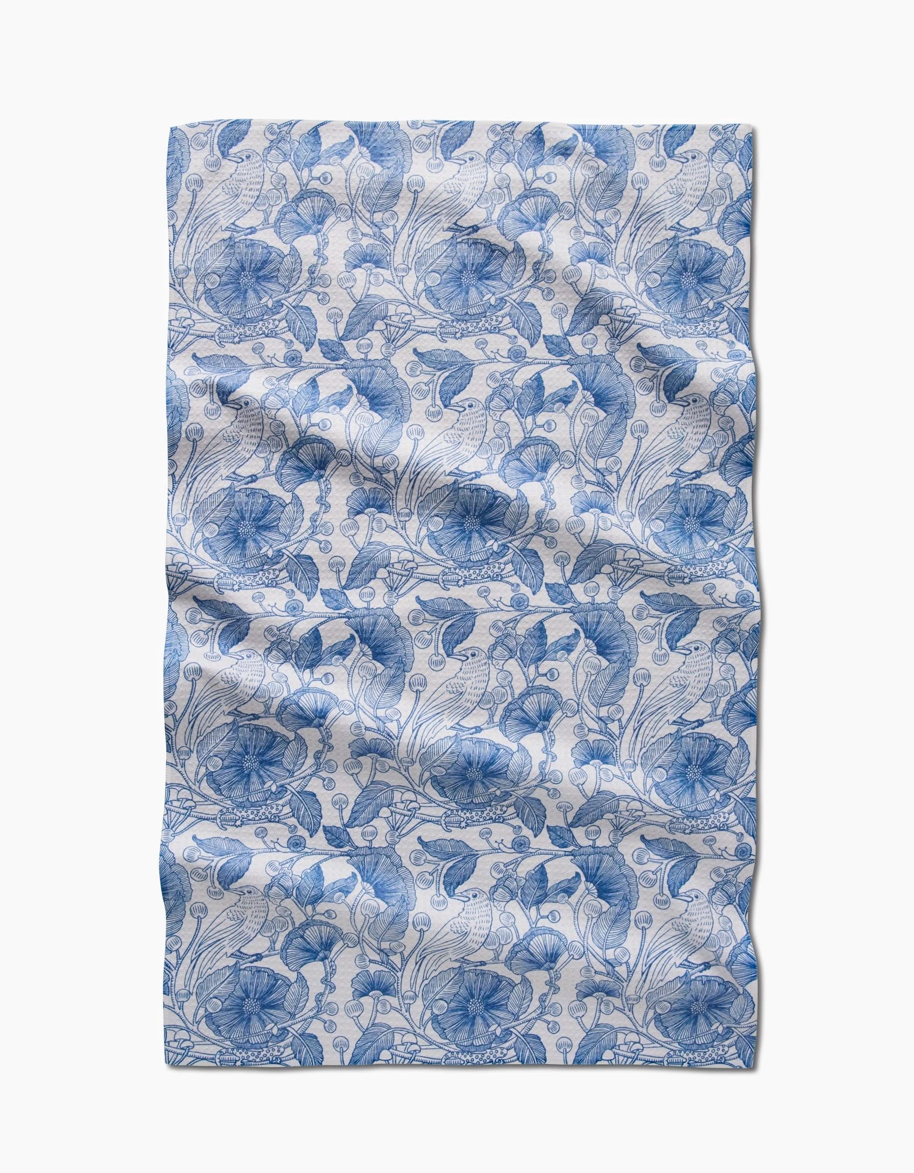 The Katie OShea Crowberries Tea Towel features a blue floral and leaf design on white, crafted from ultra-absorbent post-consumer recycled materials for sustainable style.