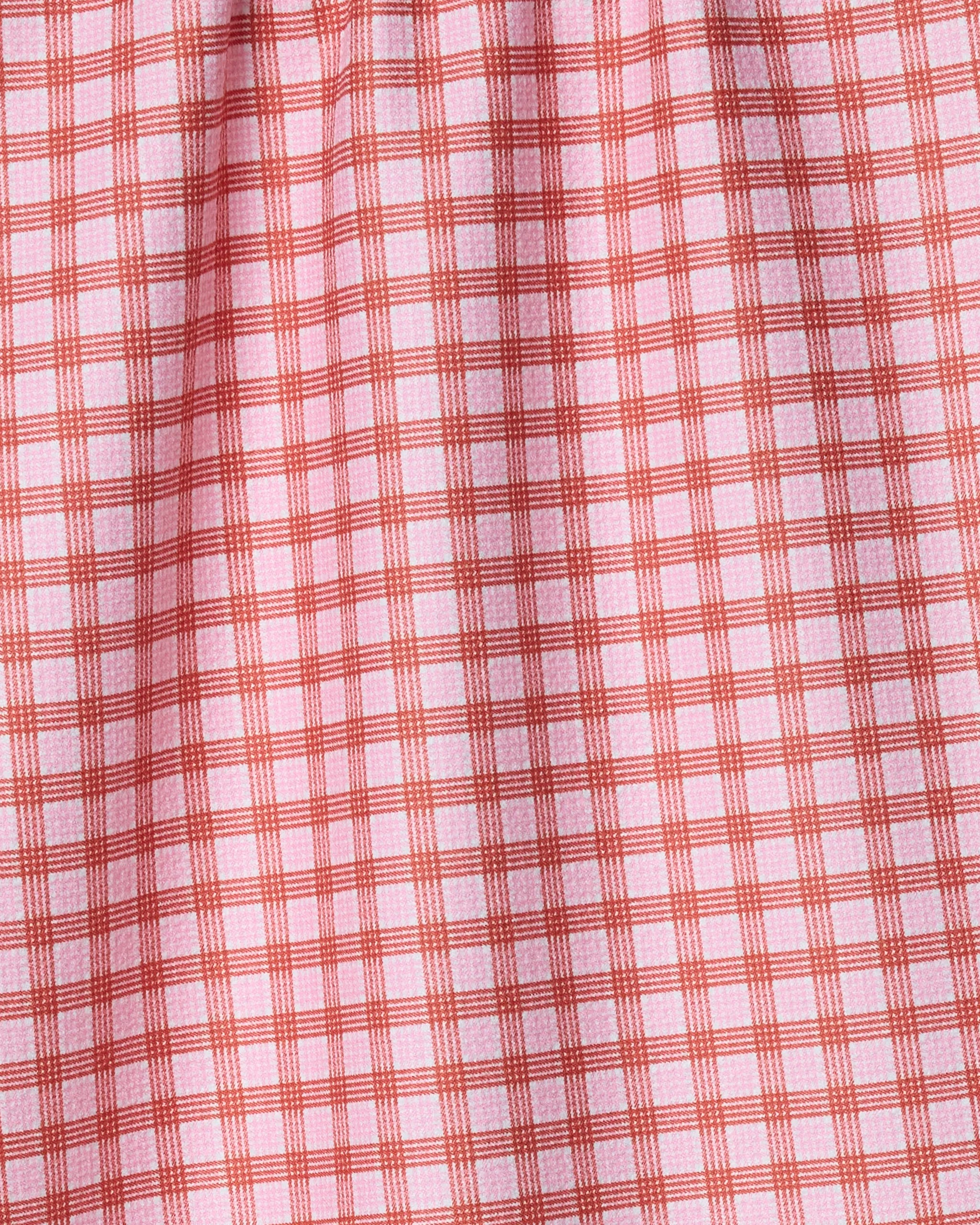 The Geometry Cupids Plaid tea towel features a red and white plaid pattern with evenly spaced lines forming small squares. Quick-drying and slightly gathered at the top, it combines style and practicality for any kitchen.