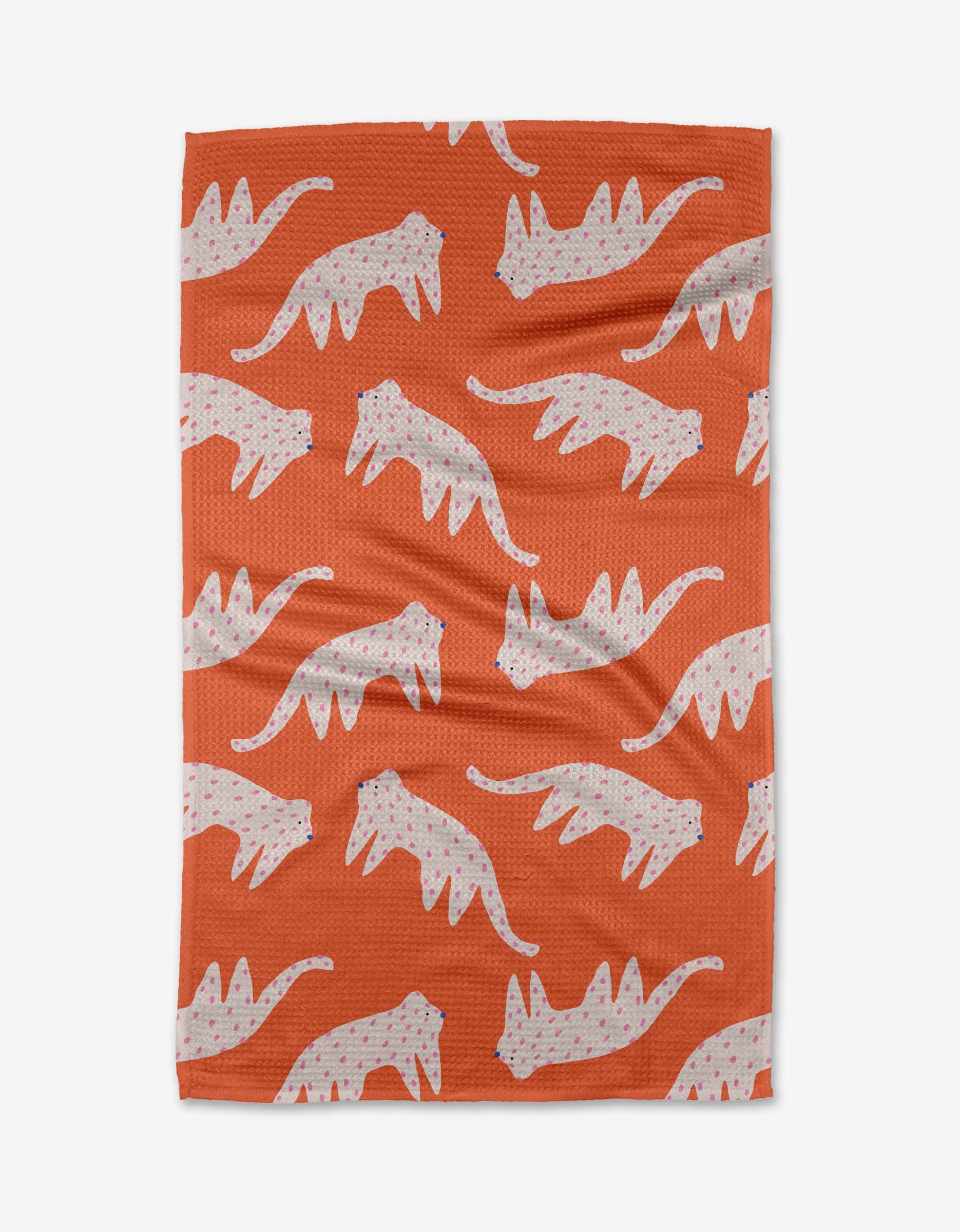 The Cute Cheetah tea towel by Jennifer Bouron features an orange background with a repeating pattern of white cheetahs with pink spots in various walking poses, evenly spread across the fabric.