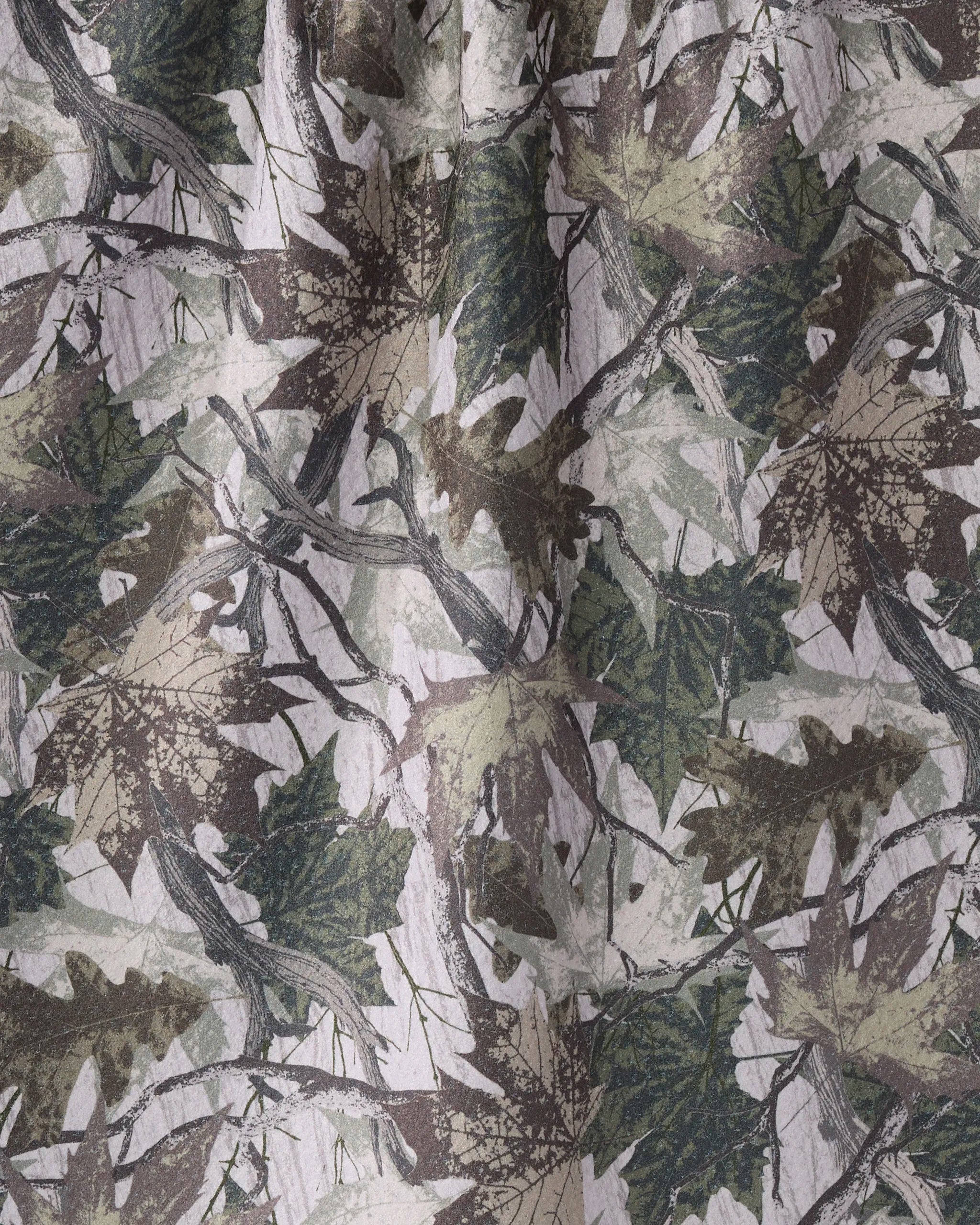A close-up of Geometry’s Dad Camo fabric, featuring overlapping green, brown, and beige leaves and branches on recycled material. Visible folds highlight its textured finish—ideal for a kitchen tea towel.