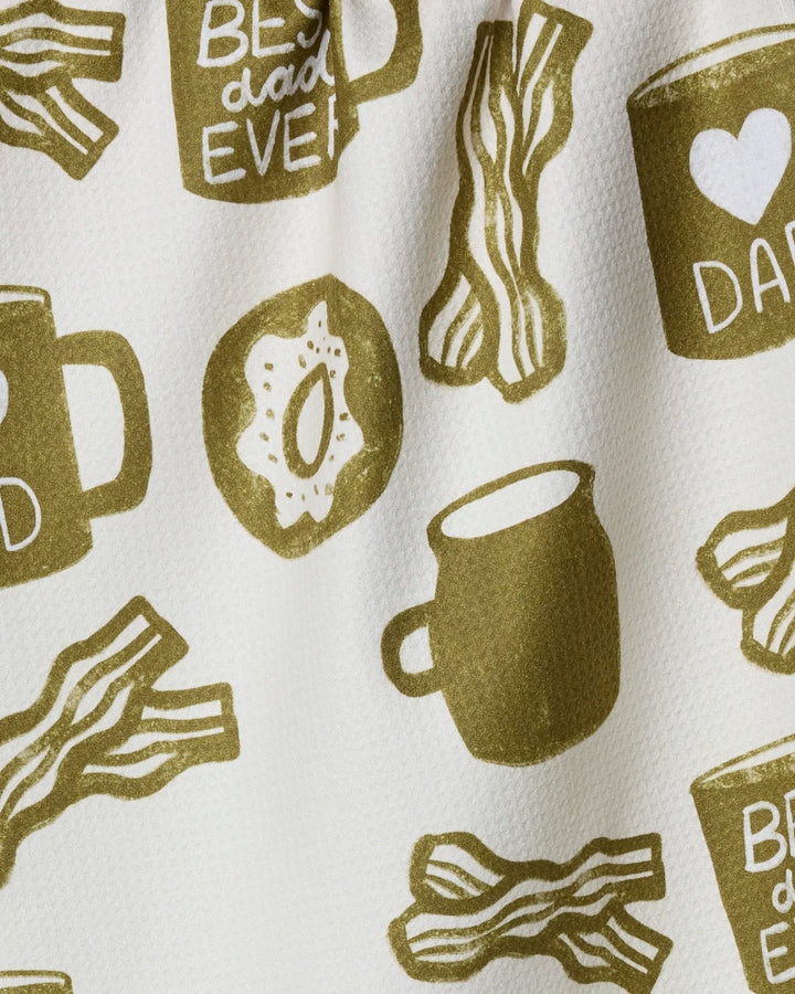 The "Dad Fuel" kitchen tea towel by Lisa Nelson features coffee mugs, bacon strips, eggs, and a heart mug with "Best Dad Ever" in greenish-brown on white—crafted from recycled materials.
