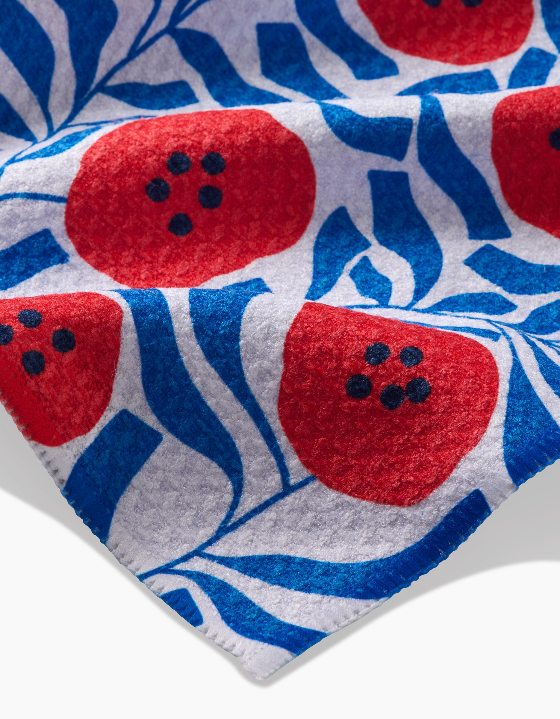 A close-up of Happy Hemeras Dancing Poppies, showcasing ultra-absorbent Geoweave fabric with a bold red poppy pattern, black-dotted centers, blue leaves, and a crisp white background.