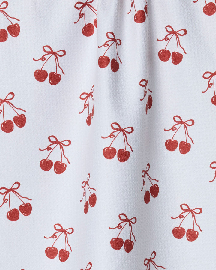 The Geometry "Darling" tea towel features a white fabric with a repeating pattern of red cherries joined by bow-tied stems. Ultra-absorbent and charming, it's perfect for adding style to your kitchen.